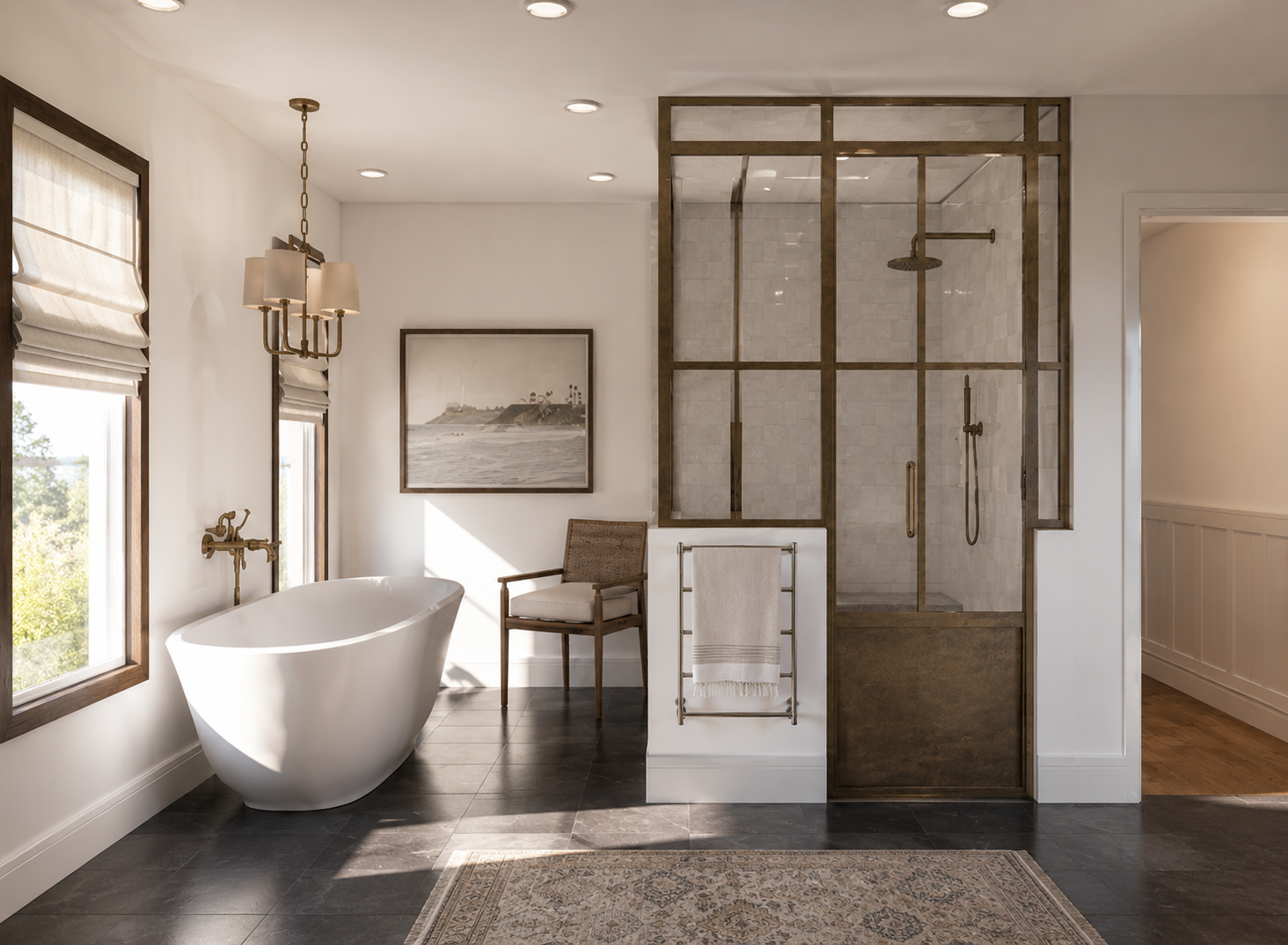 A modern bathroom with a freestanding bathtub, large windows, and a glass-enclosed shower area. Decor includes a framed seaside painting, a wooden chair, and a towel rack.