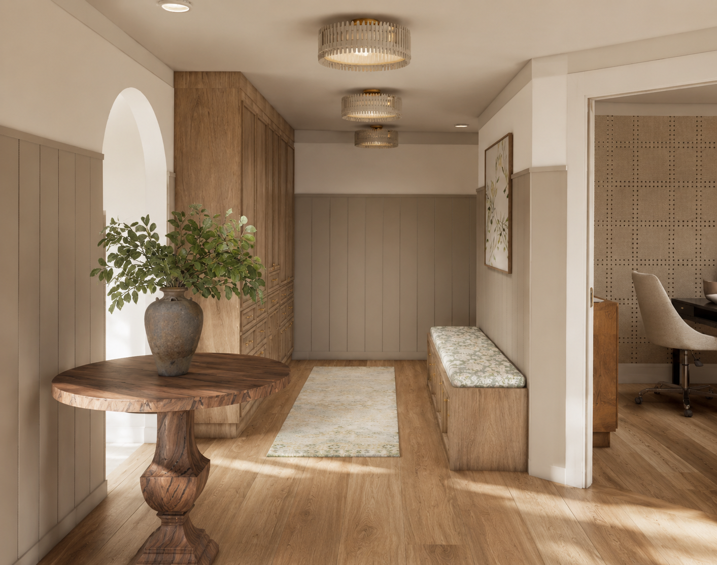 Entryway with wooden floor, built-in storage, a bench with floral cushion, large vase with green plant, and a wall with art and paneling.