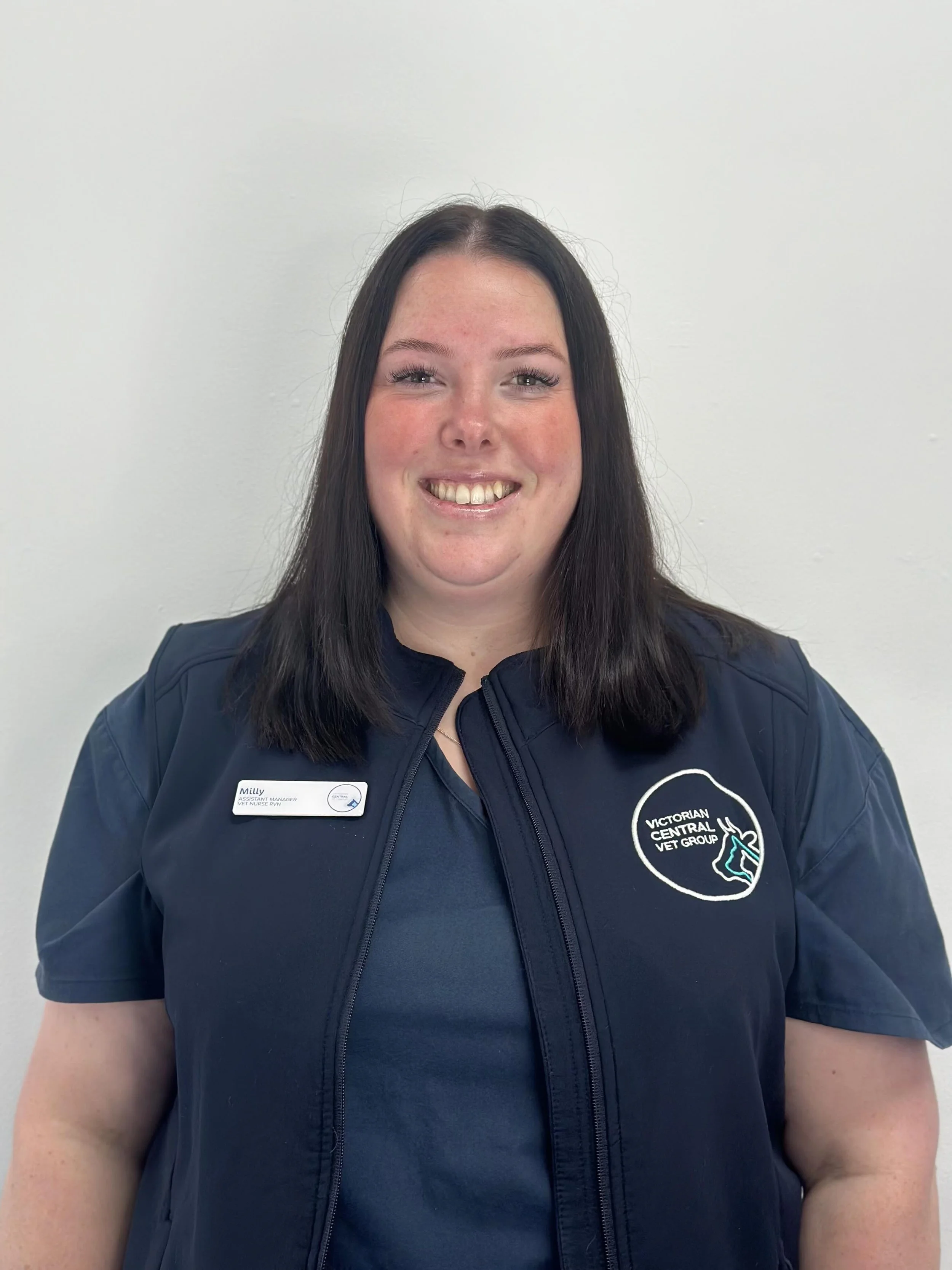 Person wearing a navy blue uniform with a name tag and a logo that says "Victorian Central Vet Group."