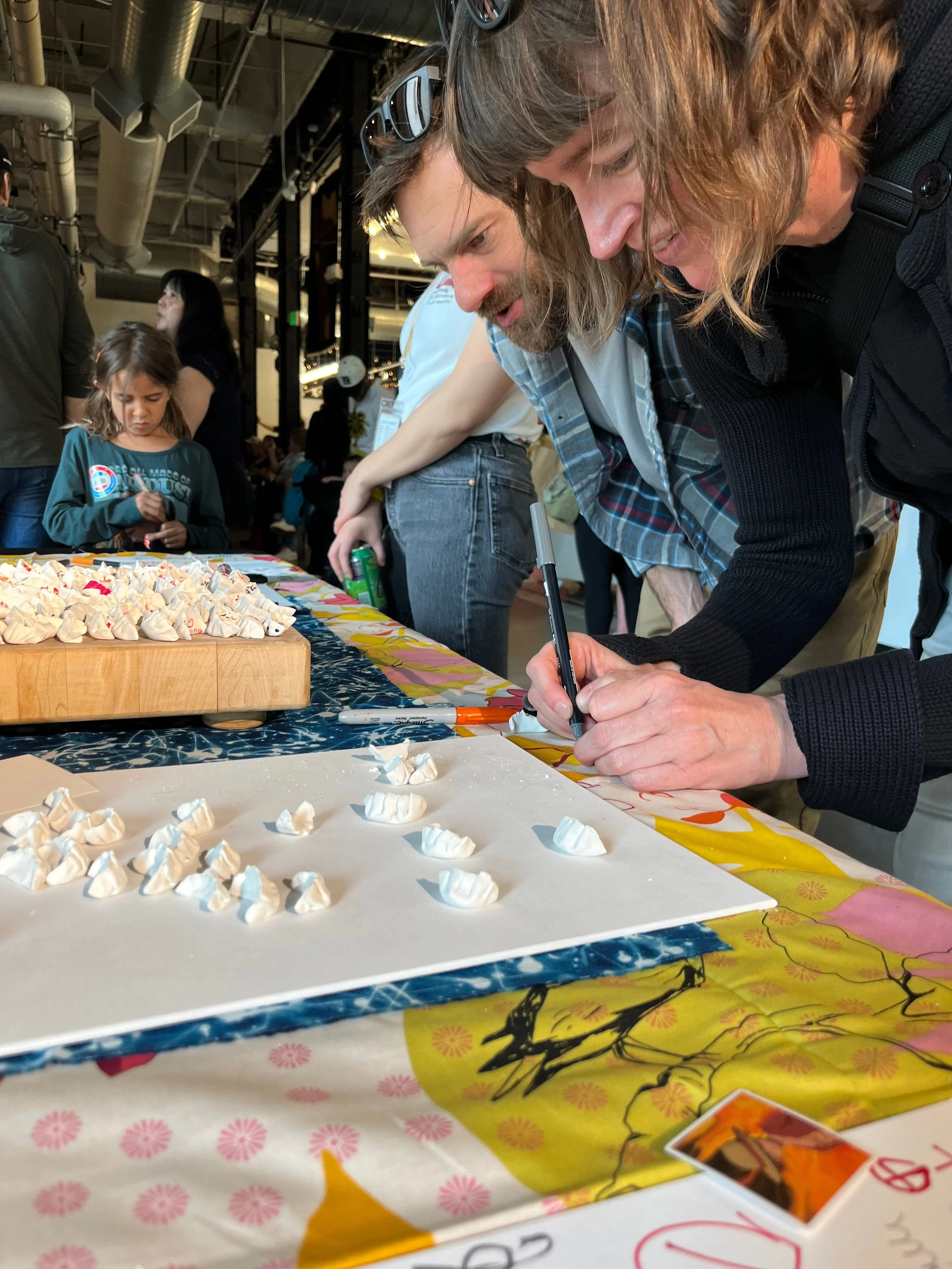 Close up of participants writing answers on dumplings