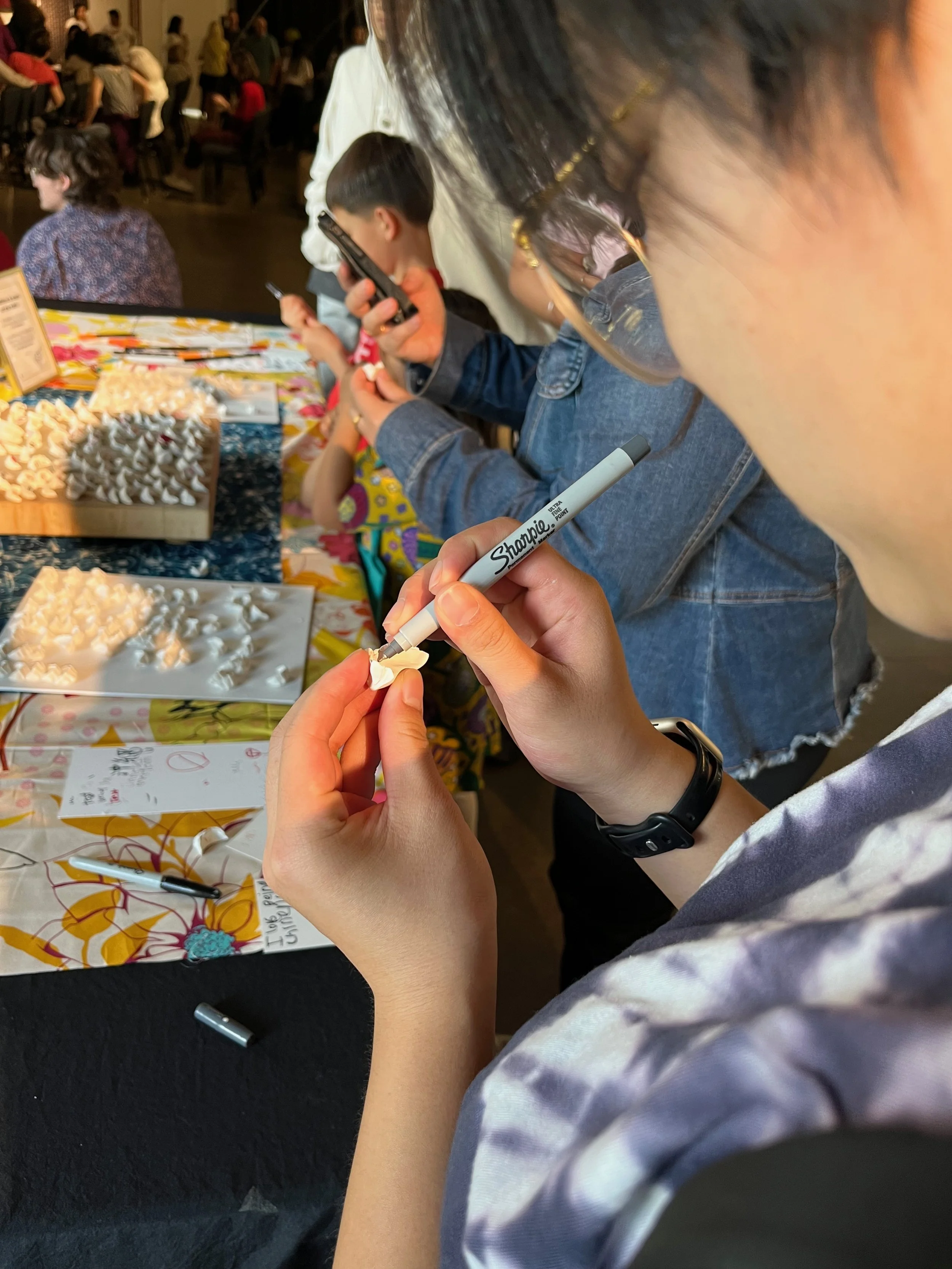Close up of participants writing answers on dumplings