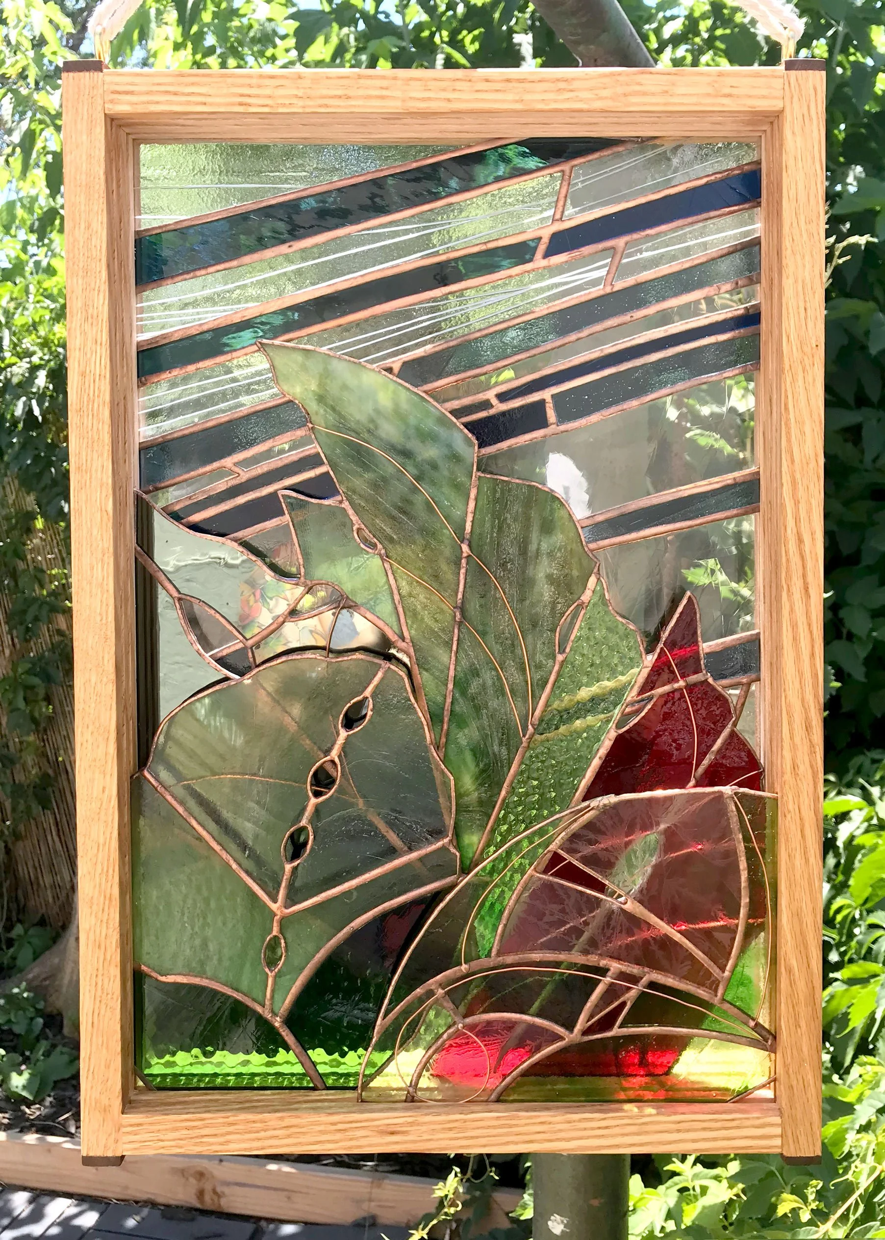 close up of layered stained glass of artful leaves in wood frame