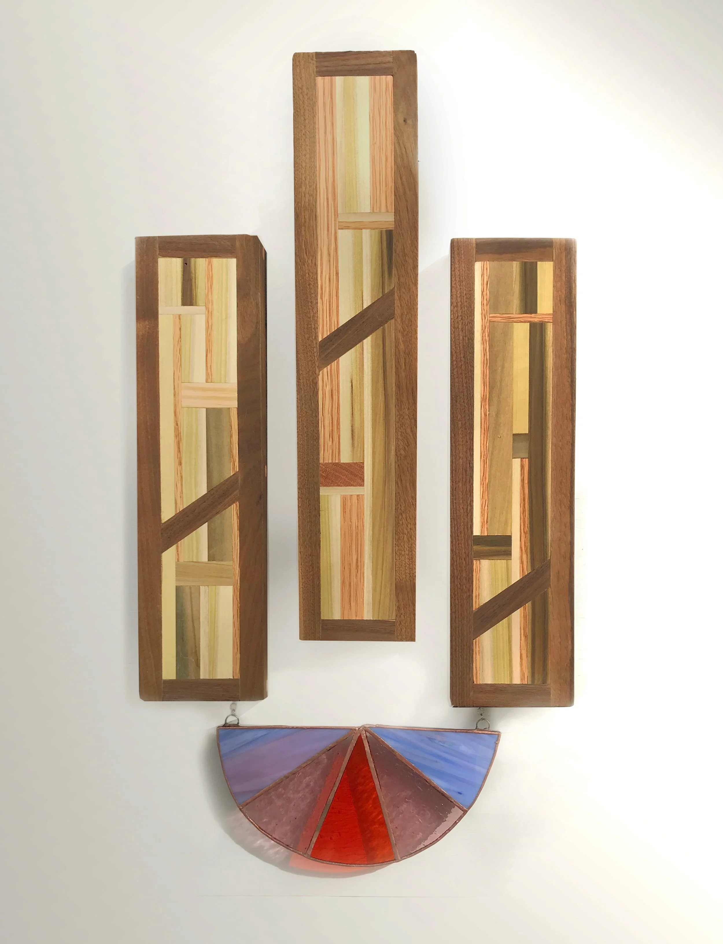 Wood and stained glass sculpture hanging on wall