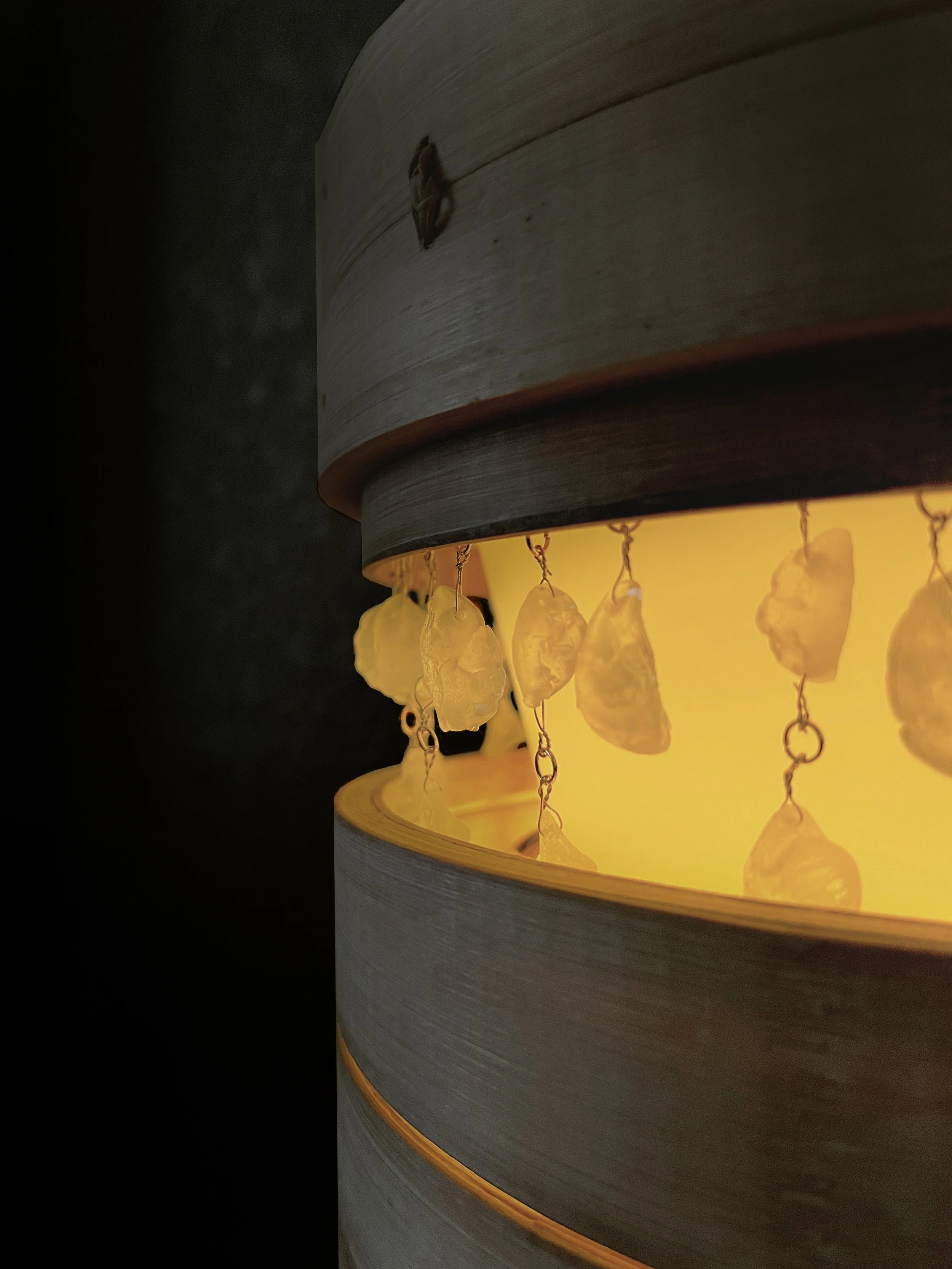Close up photo of dumpling chandelier including resin dumplings and bamboo steamer
