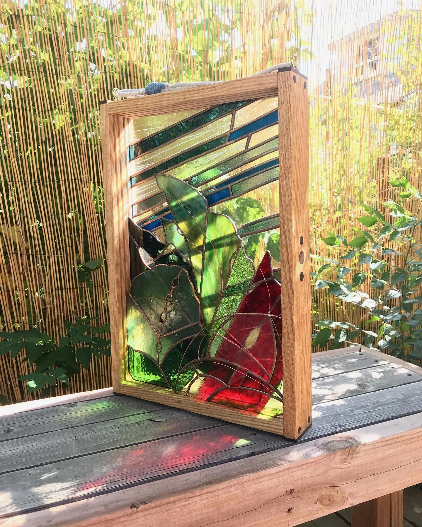 Layered stained glass of artful leaves in wood frame