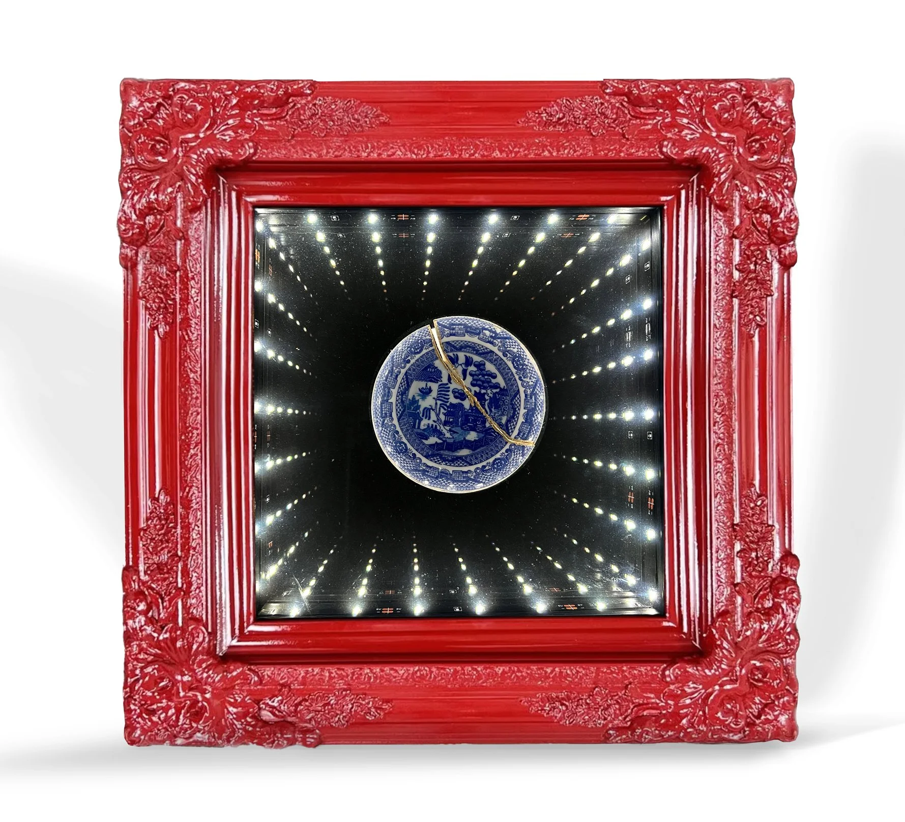 Infinity mirror with broken blue and white plate artifact in a red frame