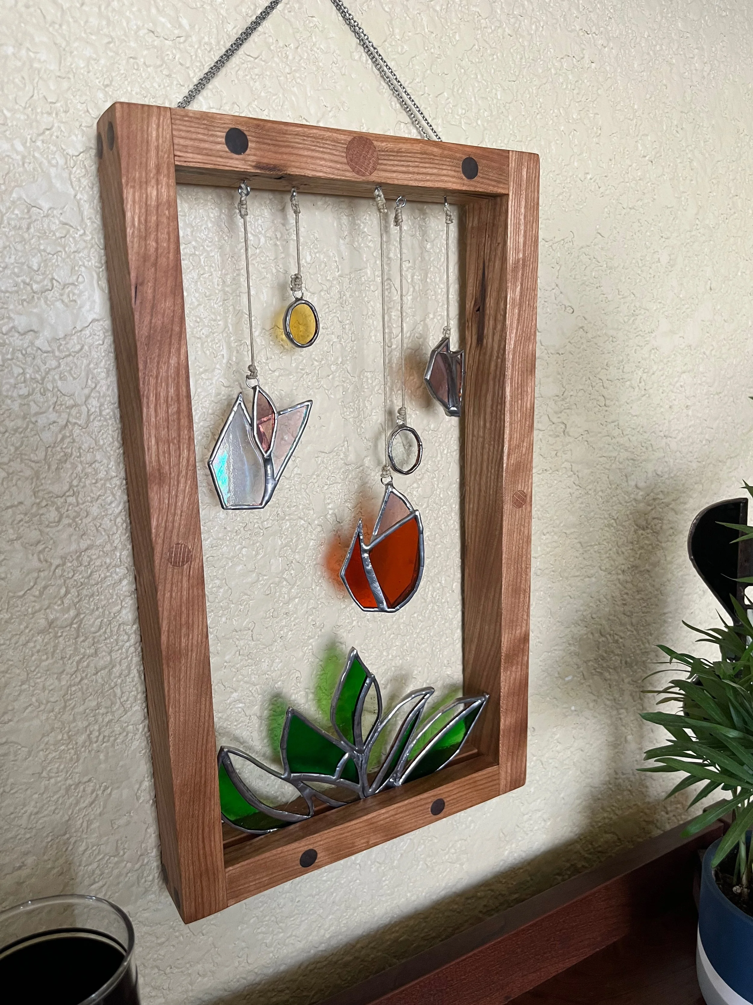 Plant and circle stained glass hanging in wood frame