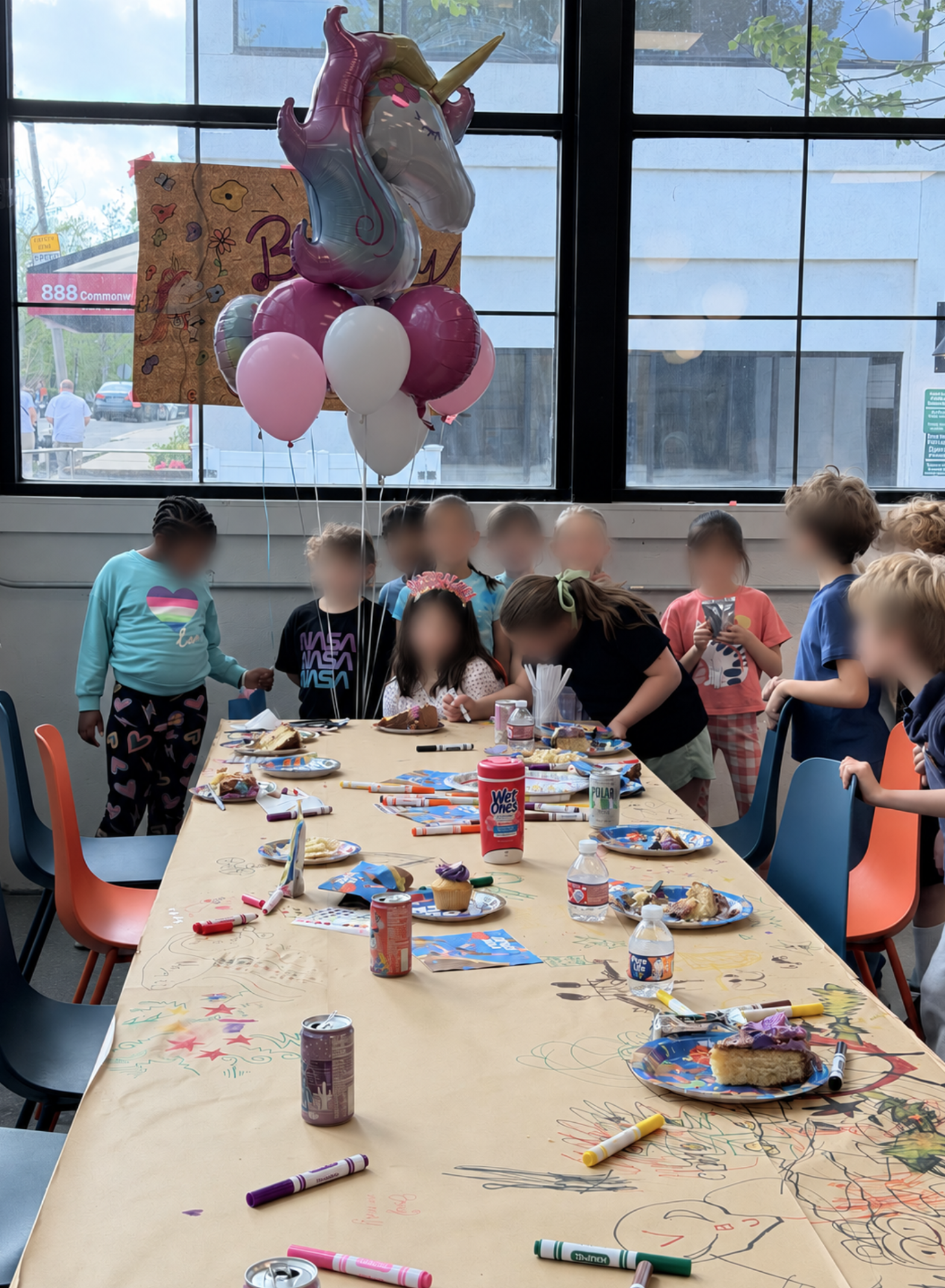 Image shows kids at a birthday table with balloons