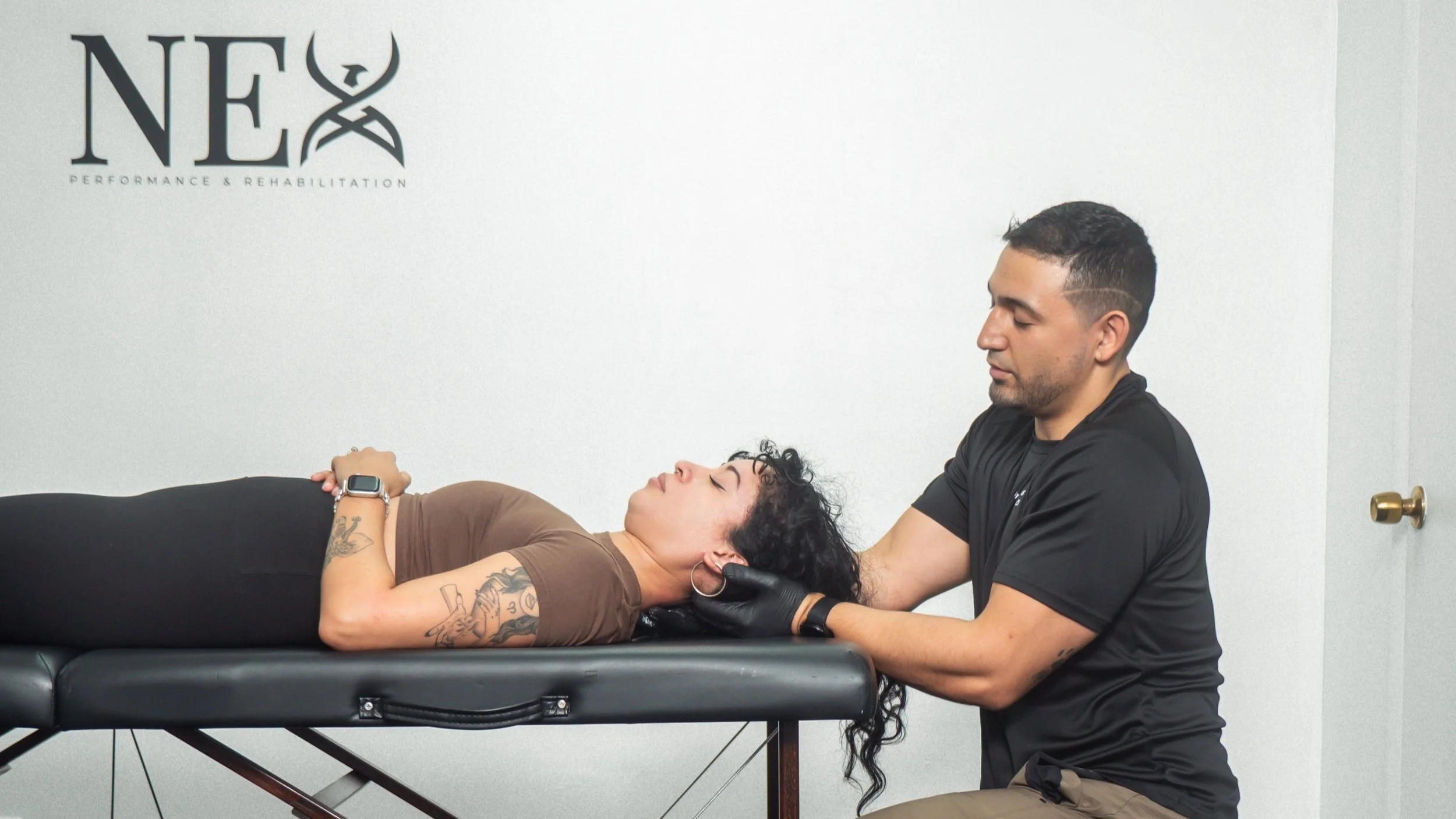 Dr. castro performing manual therapy to the neck to improve an active adults neck mobility and minimize pain in his physical therapy studio in north miami beach