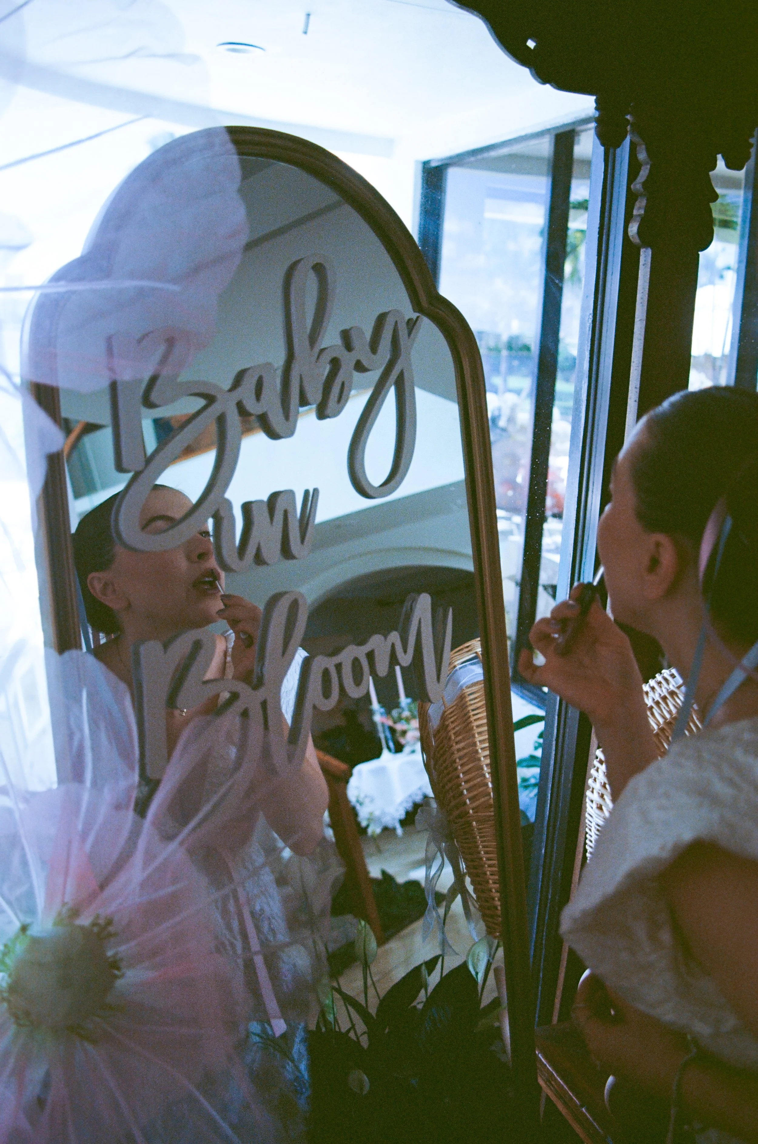 People looking at a decorative mirror with the word 'Brilliant' written on it, in a bright interior setting.