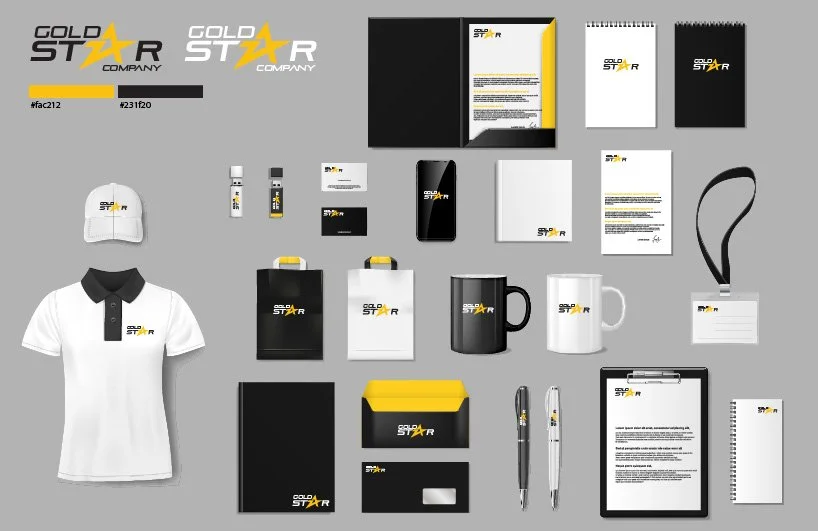 Collection of branded business items including a polo shirt, notebooks, mugs, pens, folders, a lanyard, USB drives, a smartphone, printed documents, and packaging with the Gold Star Company logo and color scheme of black, yellow, and white.