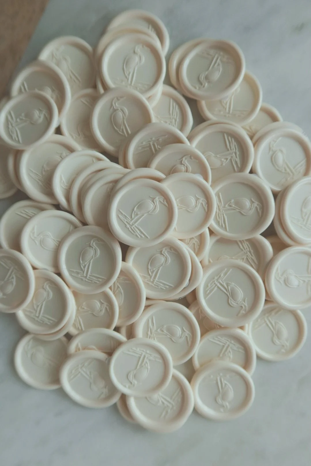 A collection of white wax seals with a heron or crane design on them.