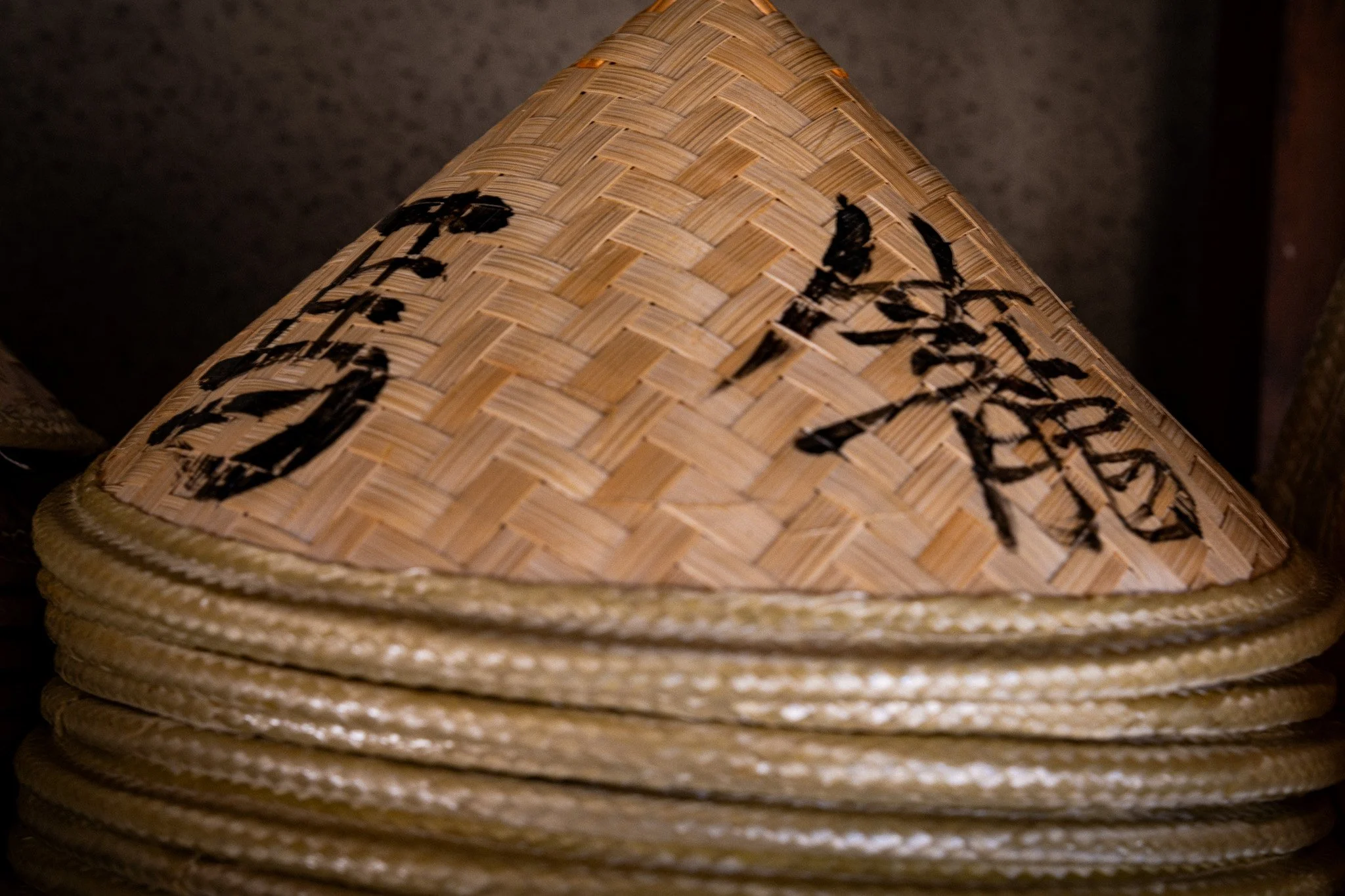 Stack of straw hats with the Japanese kanji for Magome written on them
