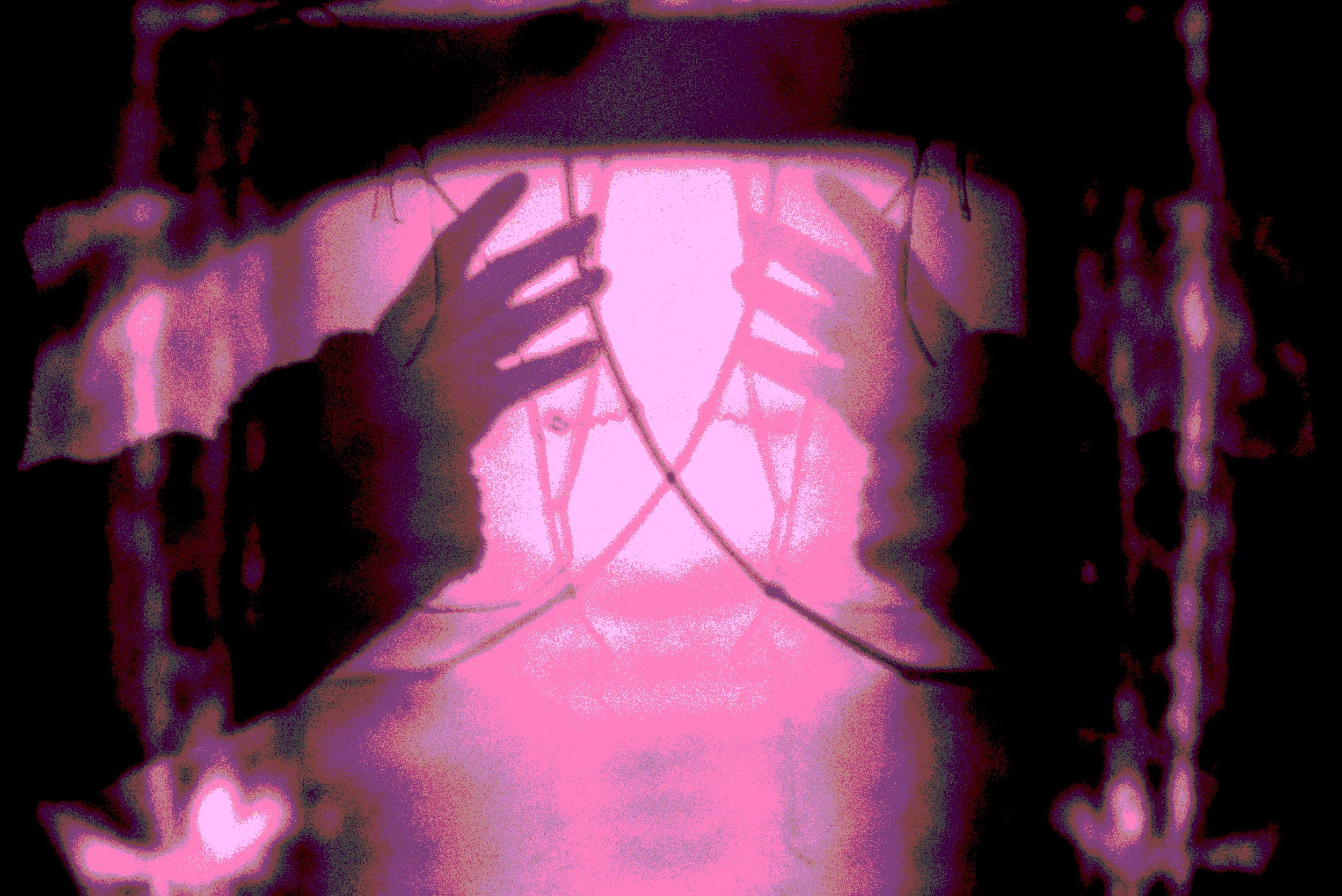 Imagem de uma pessoa segurando uma tela que exibe um coração rosa brilhante com diversas luzes e um contorno que lembra um coração, em um ambiente escuro e com uma iluminação rosa.