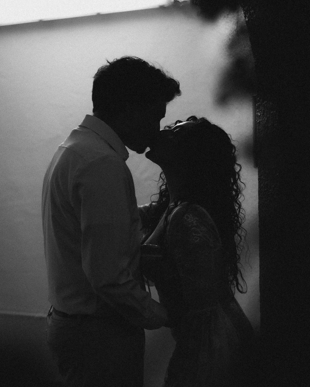 Silhouetted couple sharing a kiss in black and white. Shot at Kansas City, Country Club Plaza.