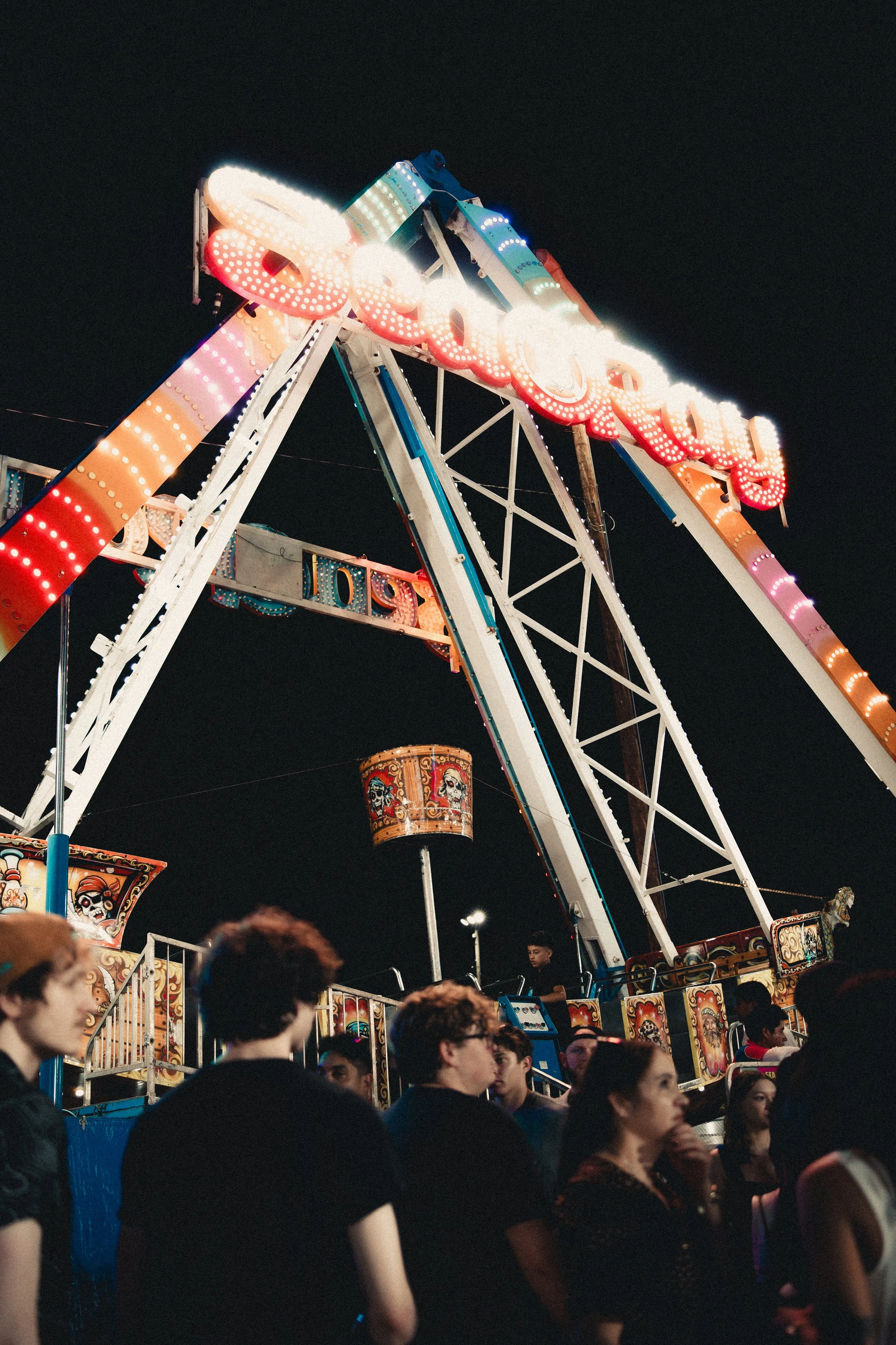 Night scene at a carnival with a Ferris wheel and a crowd of people. Shot at Fiesta Topeka.