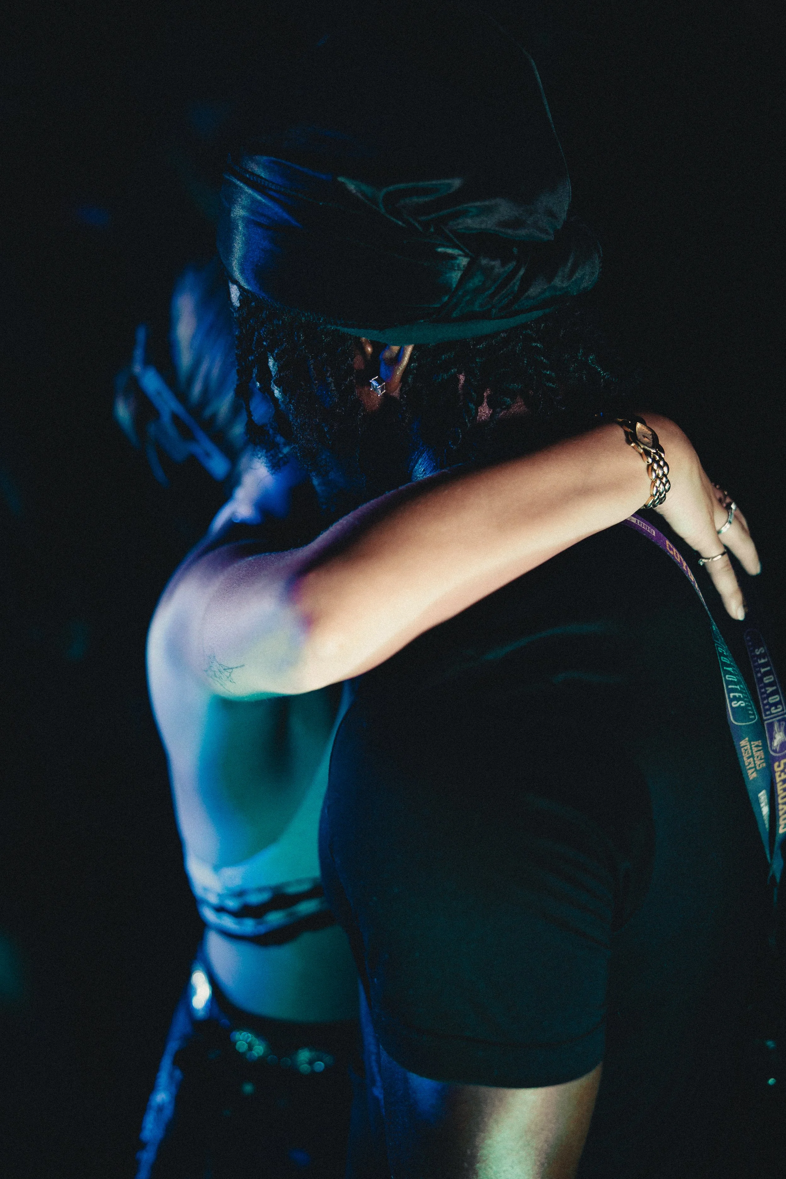Person with leather hat dancing at a club, seen from the side with neon lighting. Shot at Fiesta Topeka.