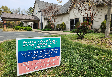 Sign with message in three languages, including Spanish and Arabic, next to our church. We welcome everyone.