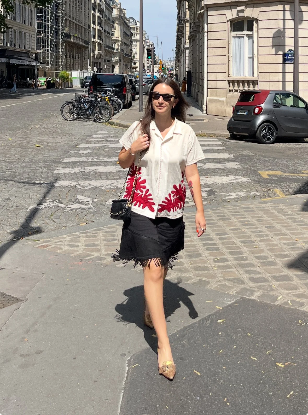 An outdoor street style photo of stylist Nadia Pizzimenti crossing a small cobblestone street for Public/Realm's tastemaker series blog post
