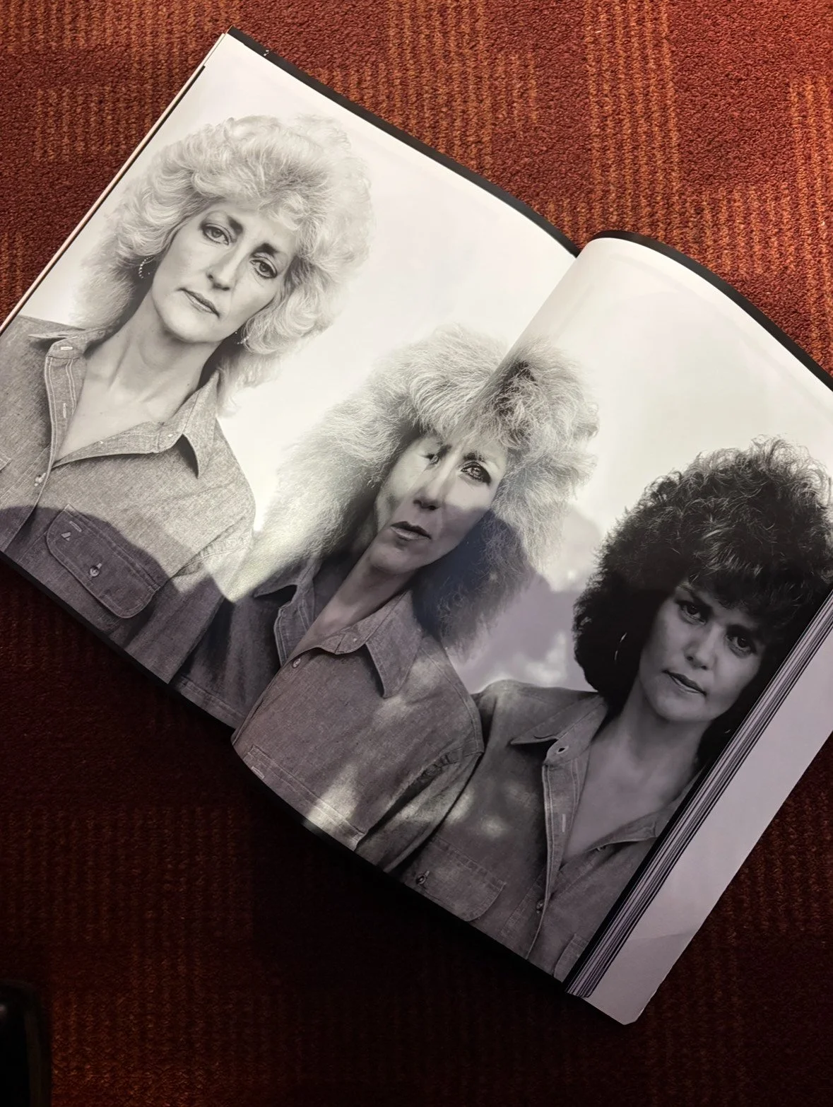A open photo book featuring a double page spread of three women with rock 'n roll haircuts styled on the retro carpet of the Toronto Reference Library for Public/Realm's tastemaker blog post series