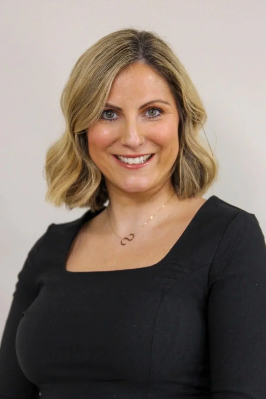 woman with brown hair wearing a black top