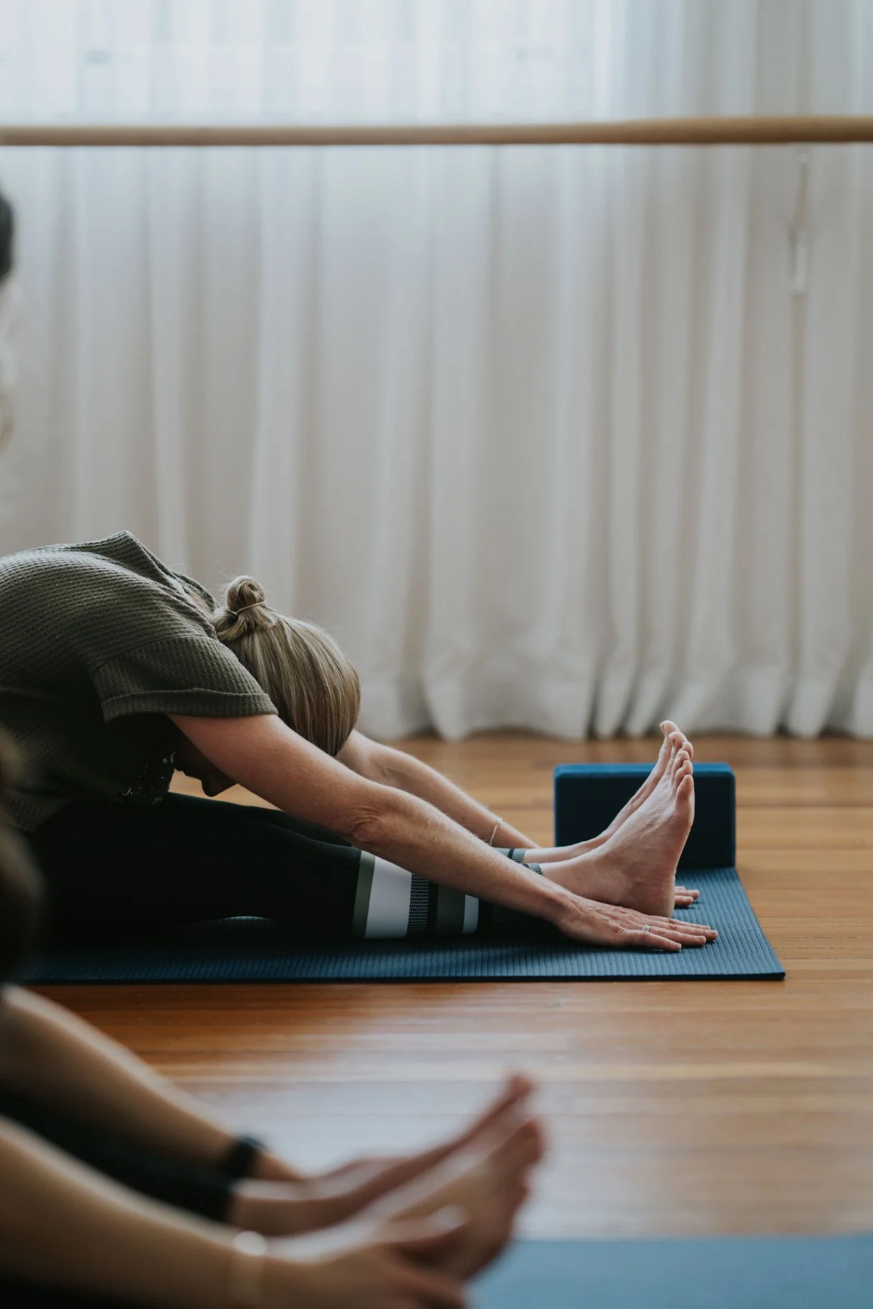 A person participating in a mat yoga class at Antara Studios