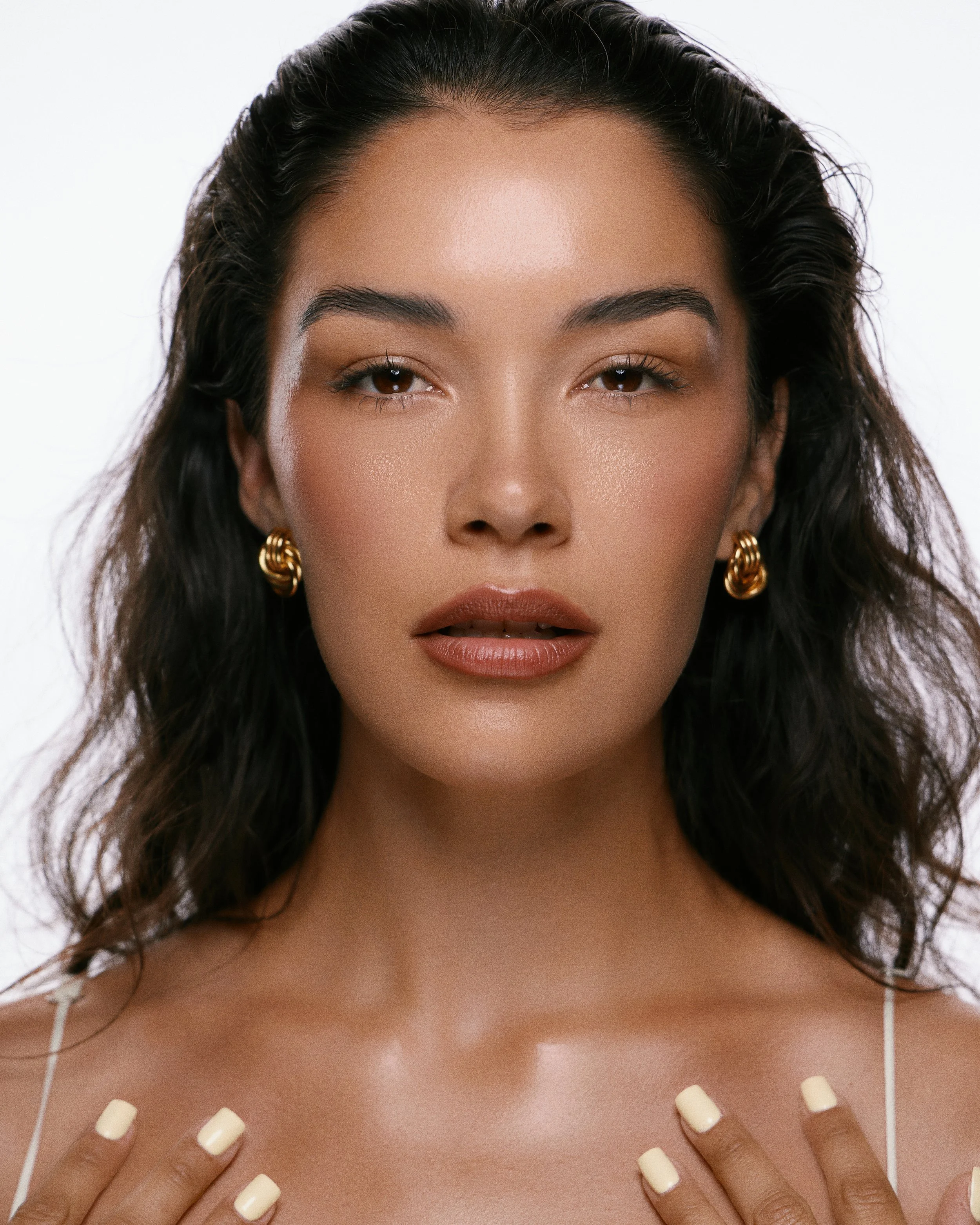 Beauty photography in Los Angeles: dewy skin and gold earrings, straight-on portrait, by Moises Martinez
