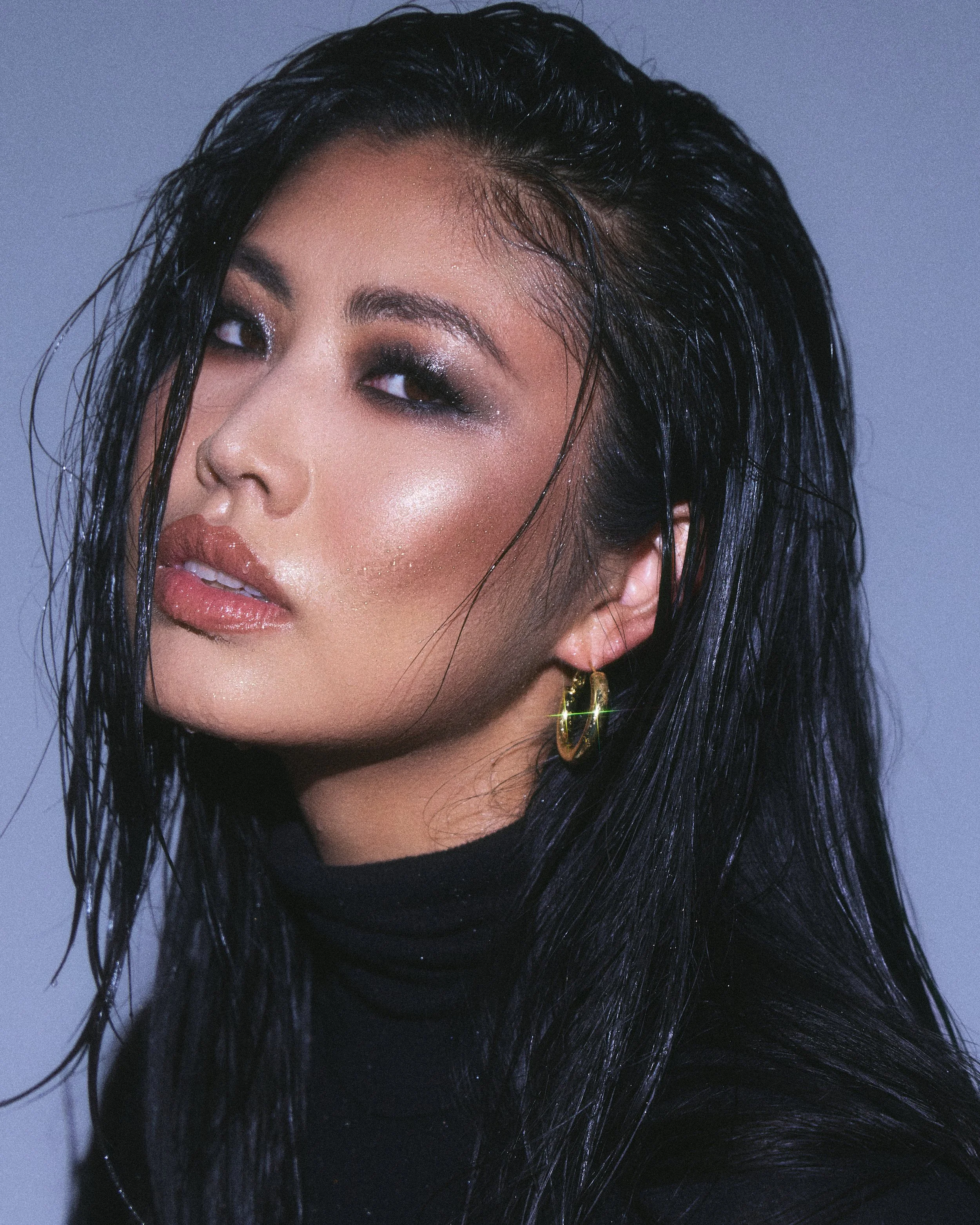 Beauty photography in Los Angeles: smoky eye glam in profile on a blue backdrop, by Moises Martinez