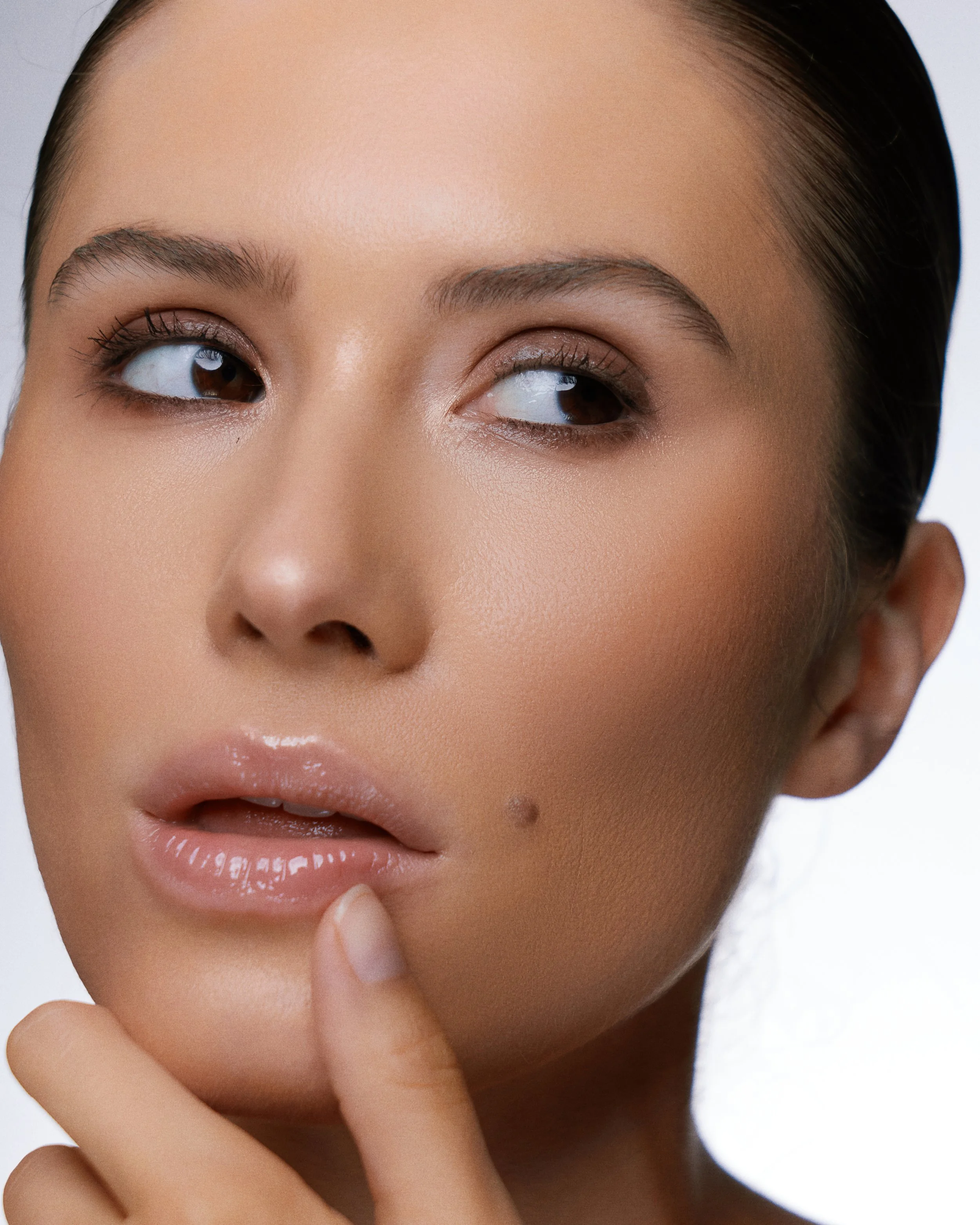 Beauty photography in Los Angeles: close-up of glowing skin and glossy lips, by Moises Martinez