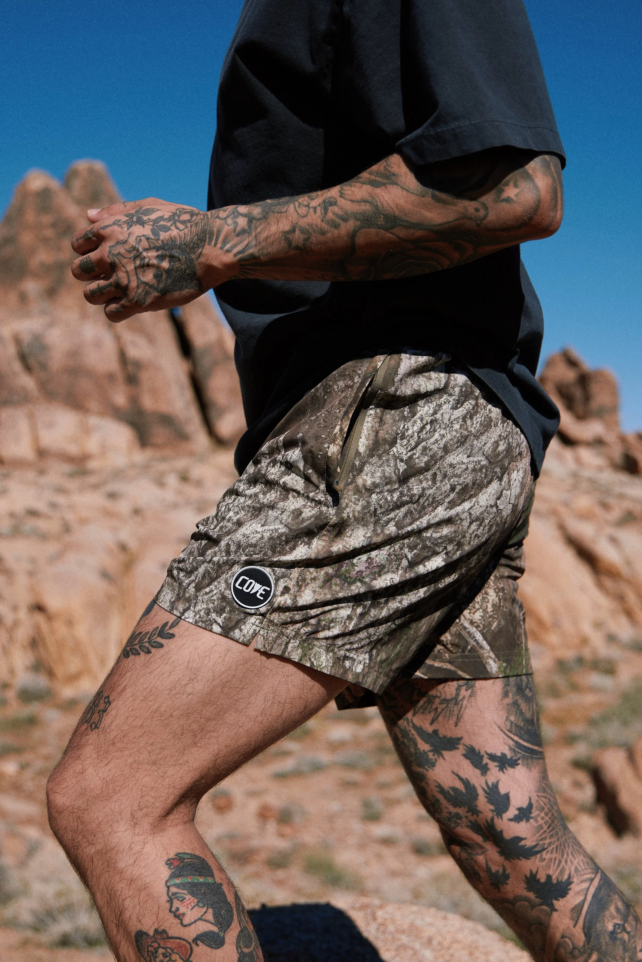 Activewear photography in Los Angeles: camo shorts mid-stride in the desert, close-up, by Moises Martinez