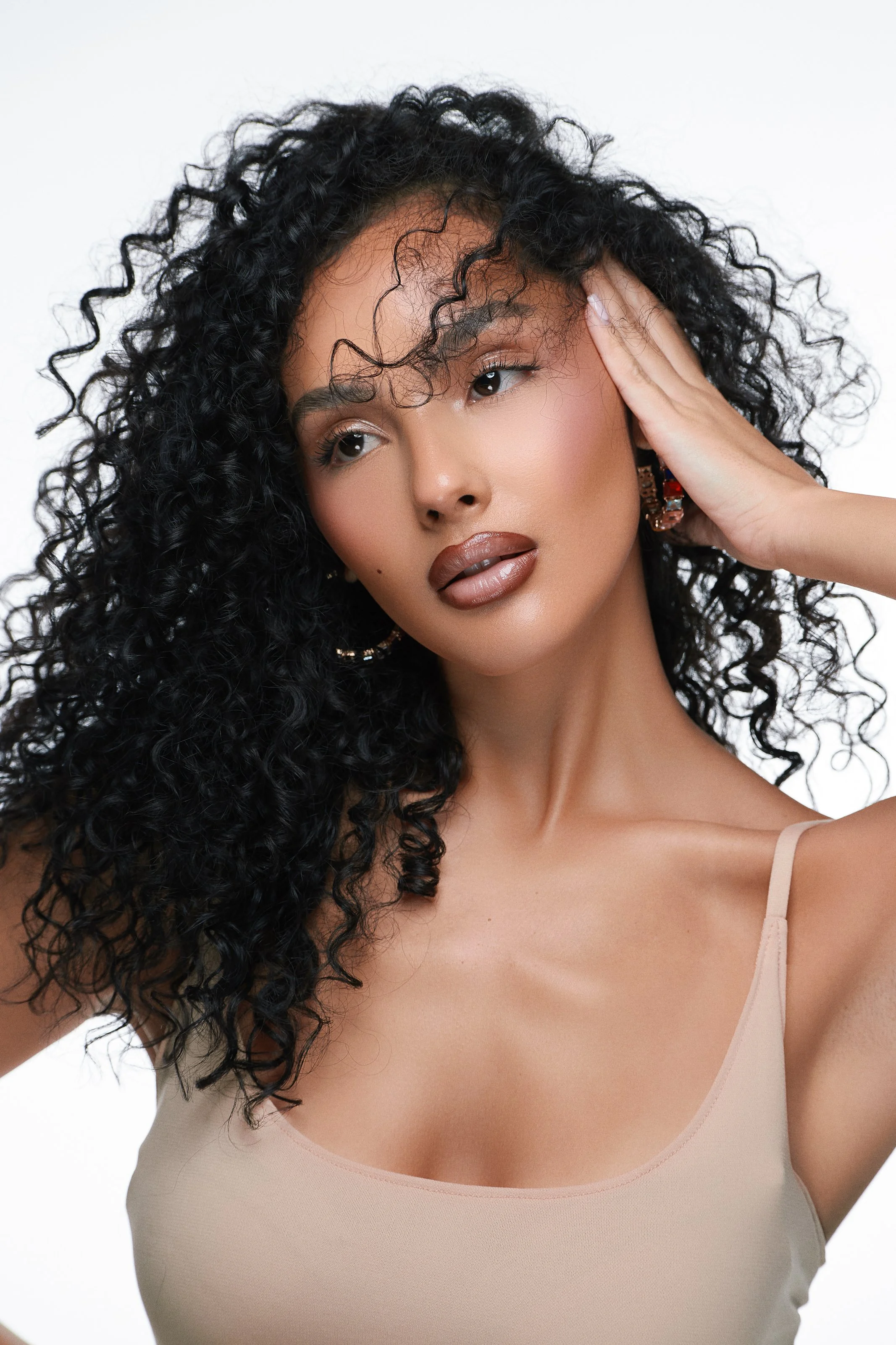 Beauty photography in Los Angeles: voluminous curly hair and natural makeup on white, by Moises Martinez