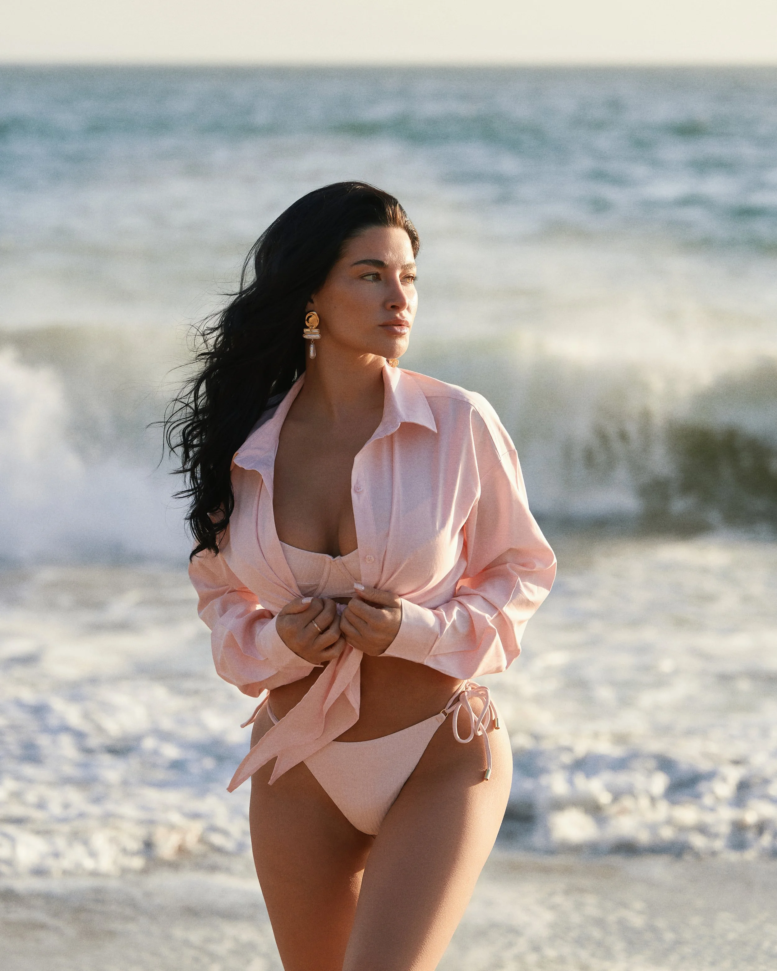 Swimwear photography in Los Angeles: pink shirt and bikini in the ocean surf, by Moises Martinez