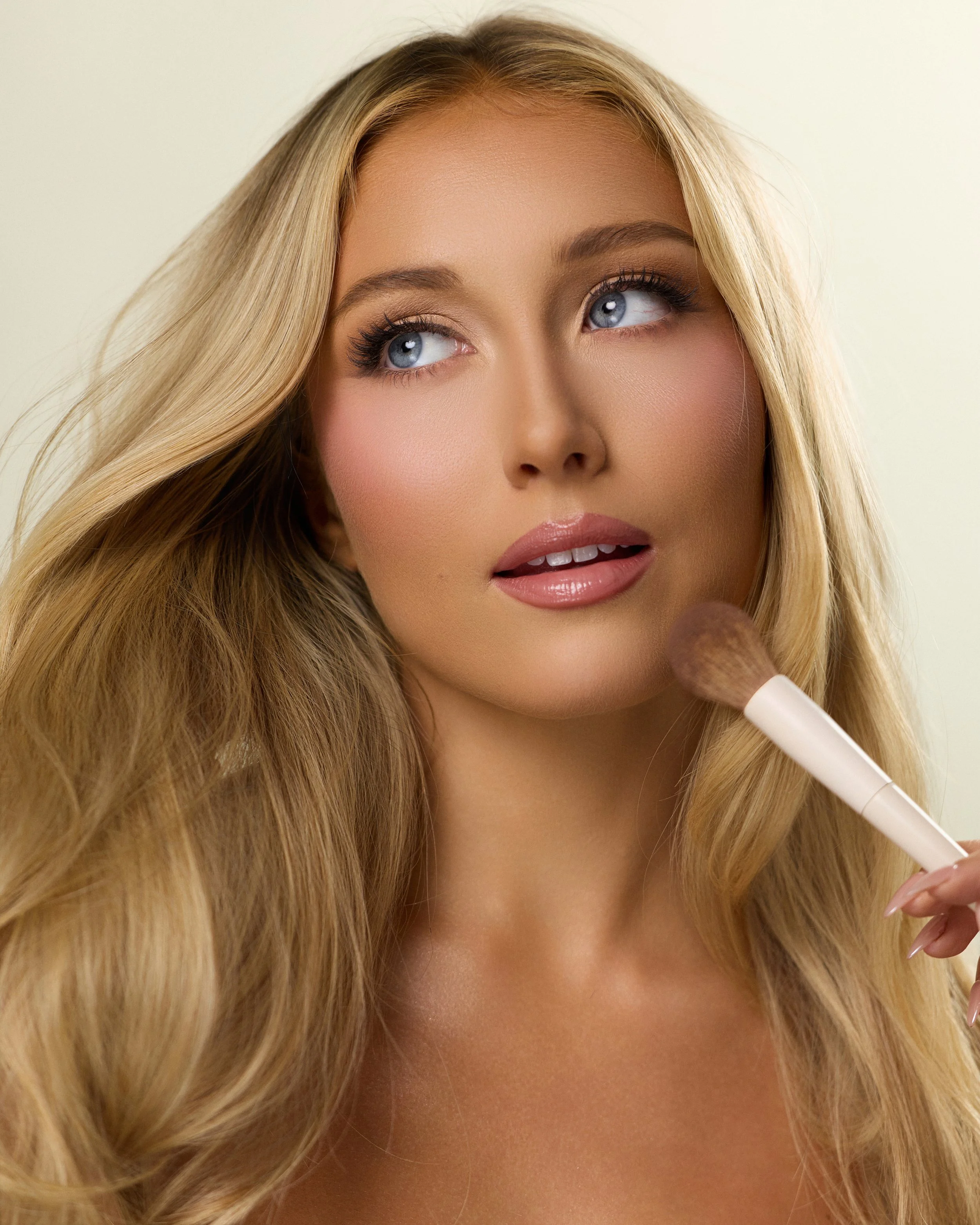Beauty photography in Los Angeles: makeup brush and windswept blonde hair, by Moises Martinez