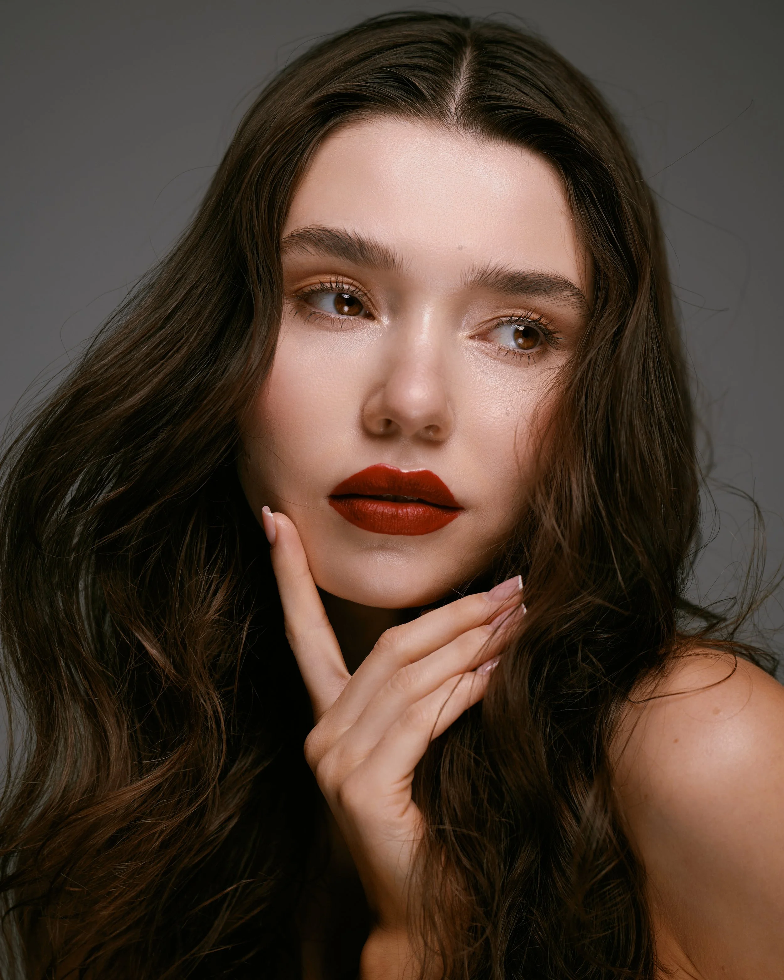 Beauty photography in Los Angeles: red lip and soft waves on a dark backdrop, by Moises Martinez