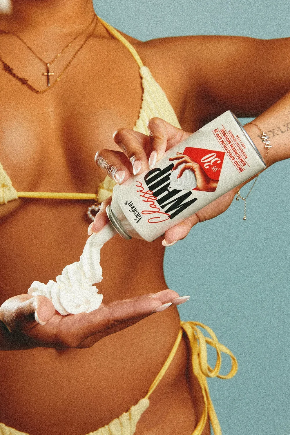 Person pouring whipped cream from a can labeled 'Whip It!' into their hand.