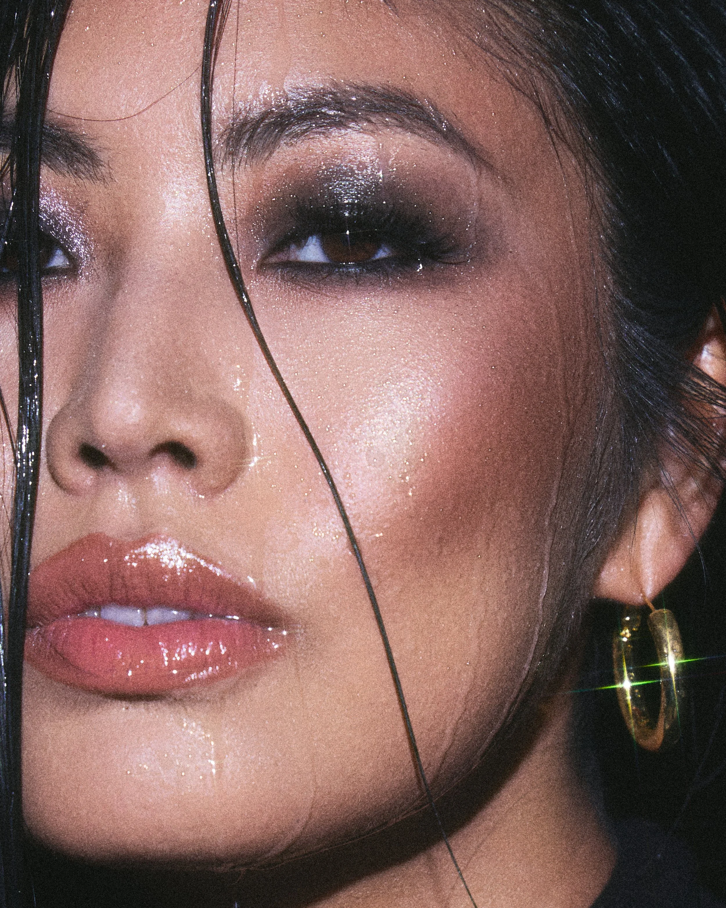 Beauty photography in Los Angeles: extreme close-up of glossy lips and a gold hoop earring, by Moises Martinez
