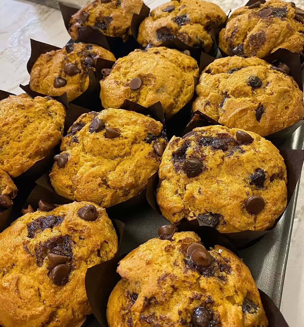 Pumpkin chocolate chip muffins in a baking tray.