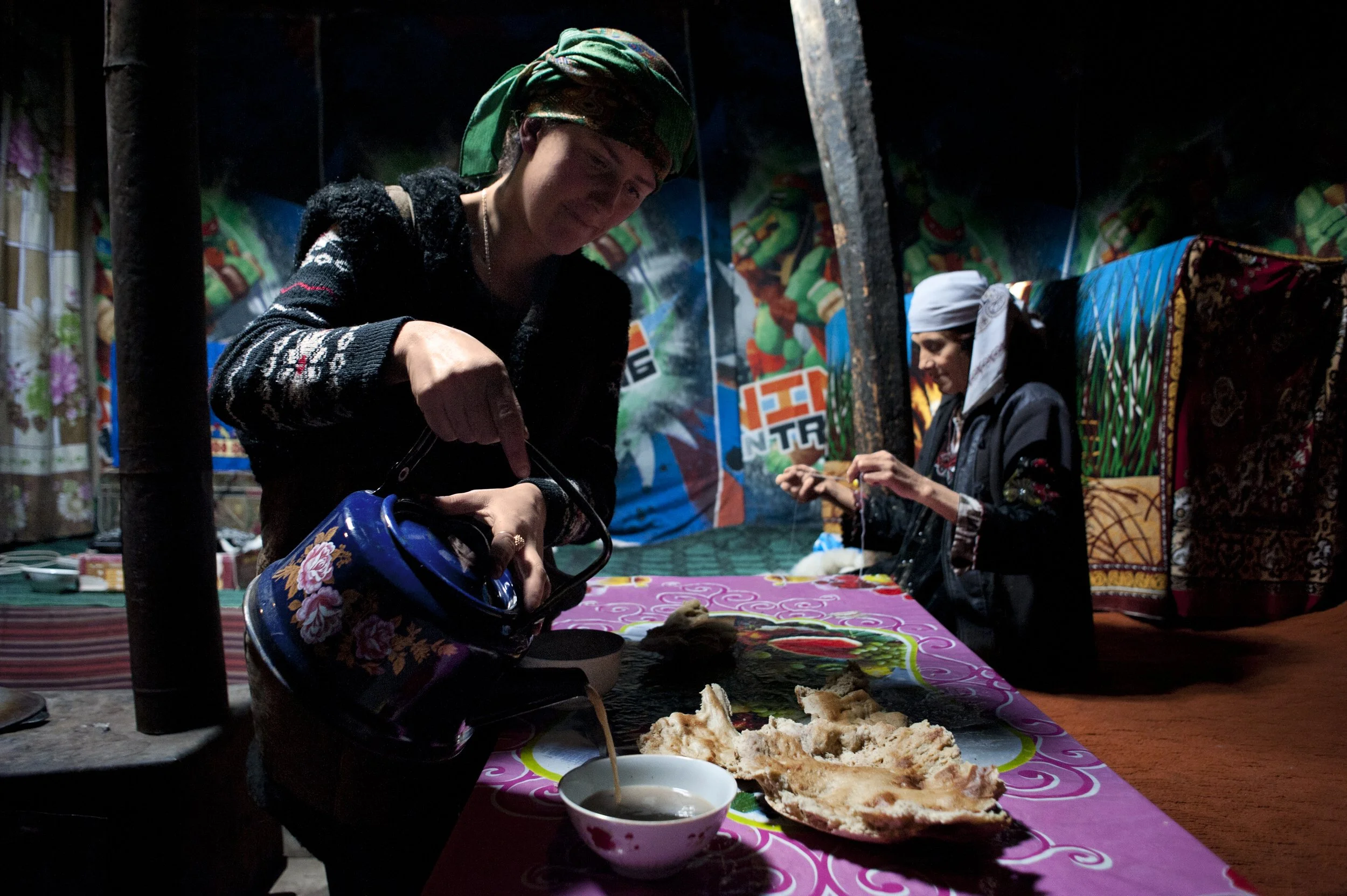 Her daughter is serving a tea. Odinamo spent all her life in Roshorv. She is the mother of 9 children. Two daughters still live with them. She also takes care of her two grandchildren as their parents work in Khorog, a 7 hour drive away. Her older gr