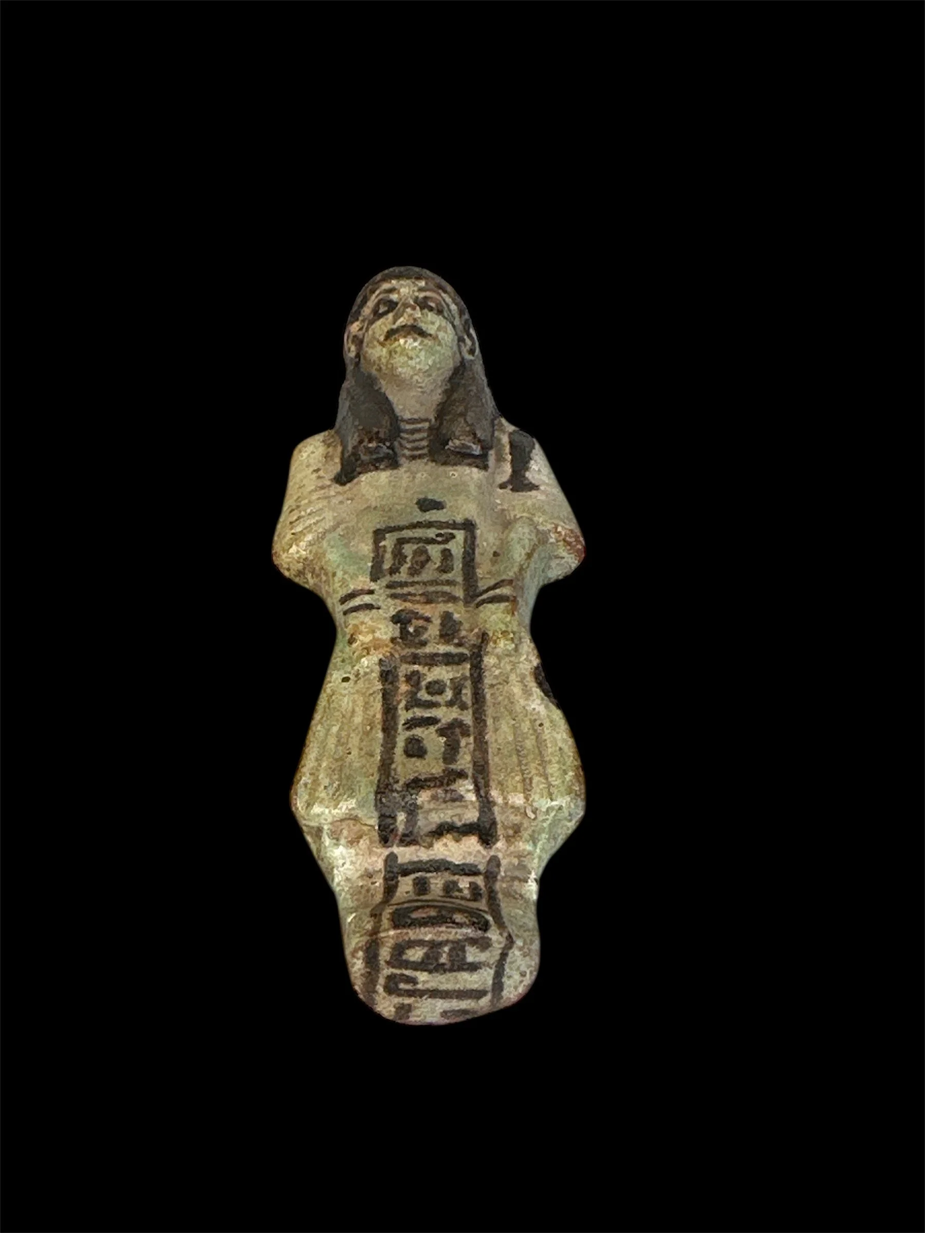 Ancient Egyptian shabti figure with hieroglyphics, black hair, depicted against a black background.