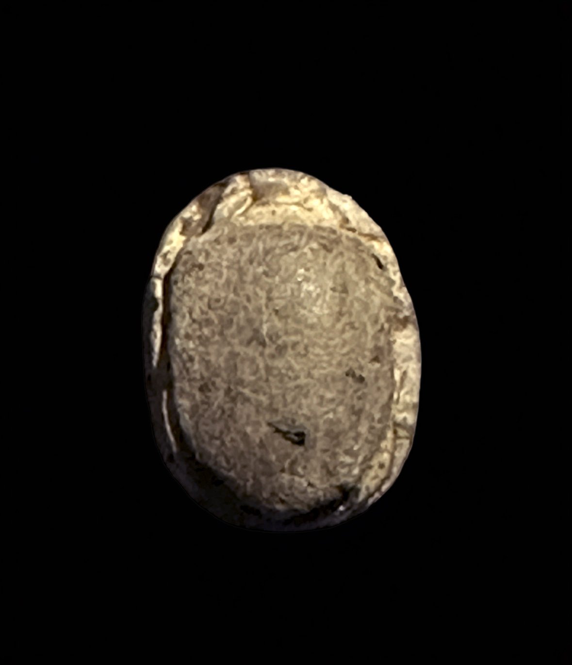 Close-up of an ancient coin or medal against a black background.