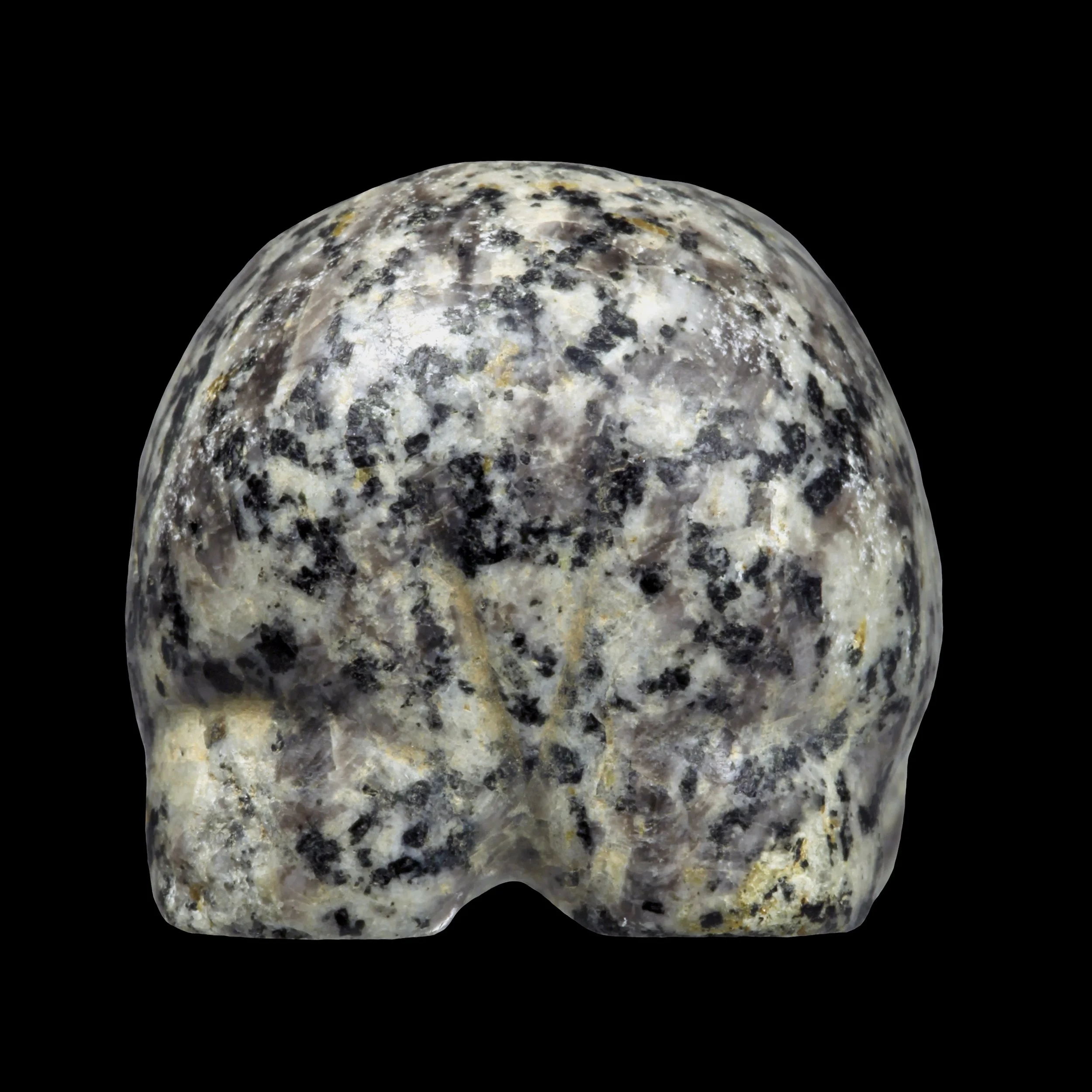 A hippopotamus sculpture made from speckled black, white, and gray stone with a smooth surface, set against a black background.