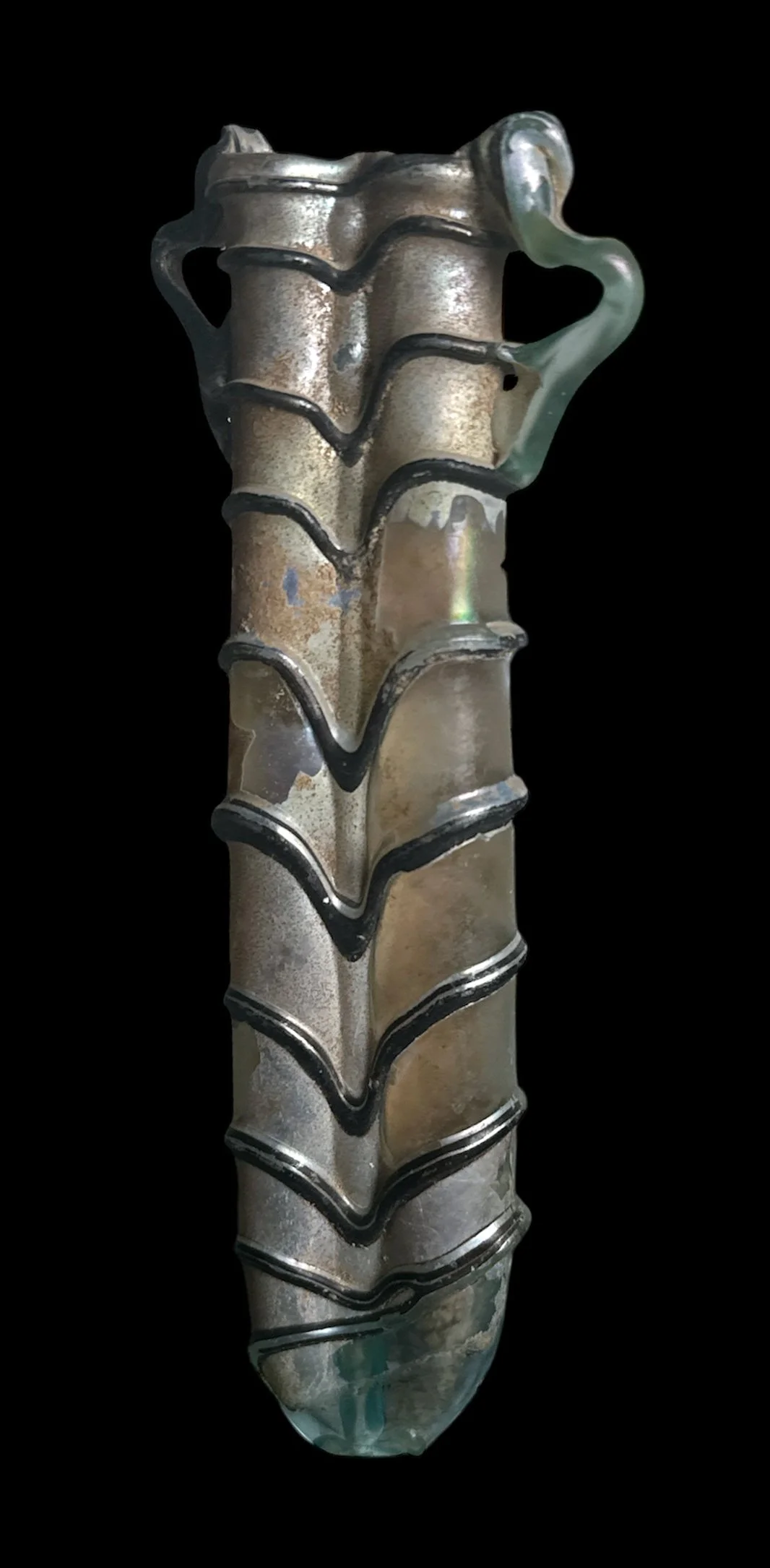 A metal object resembling a bejeweled or decorative handle or sculpture with a textured surface and curved black accents, set against a black background.
