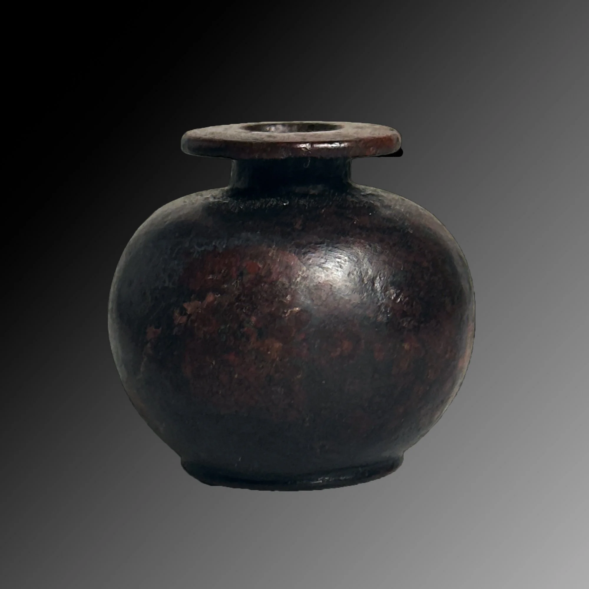 Ancient dark-glazed bronze vessel with a rounded body and short neck, against a gradient gray background.