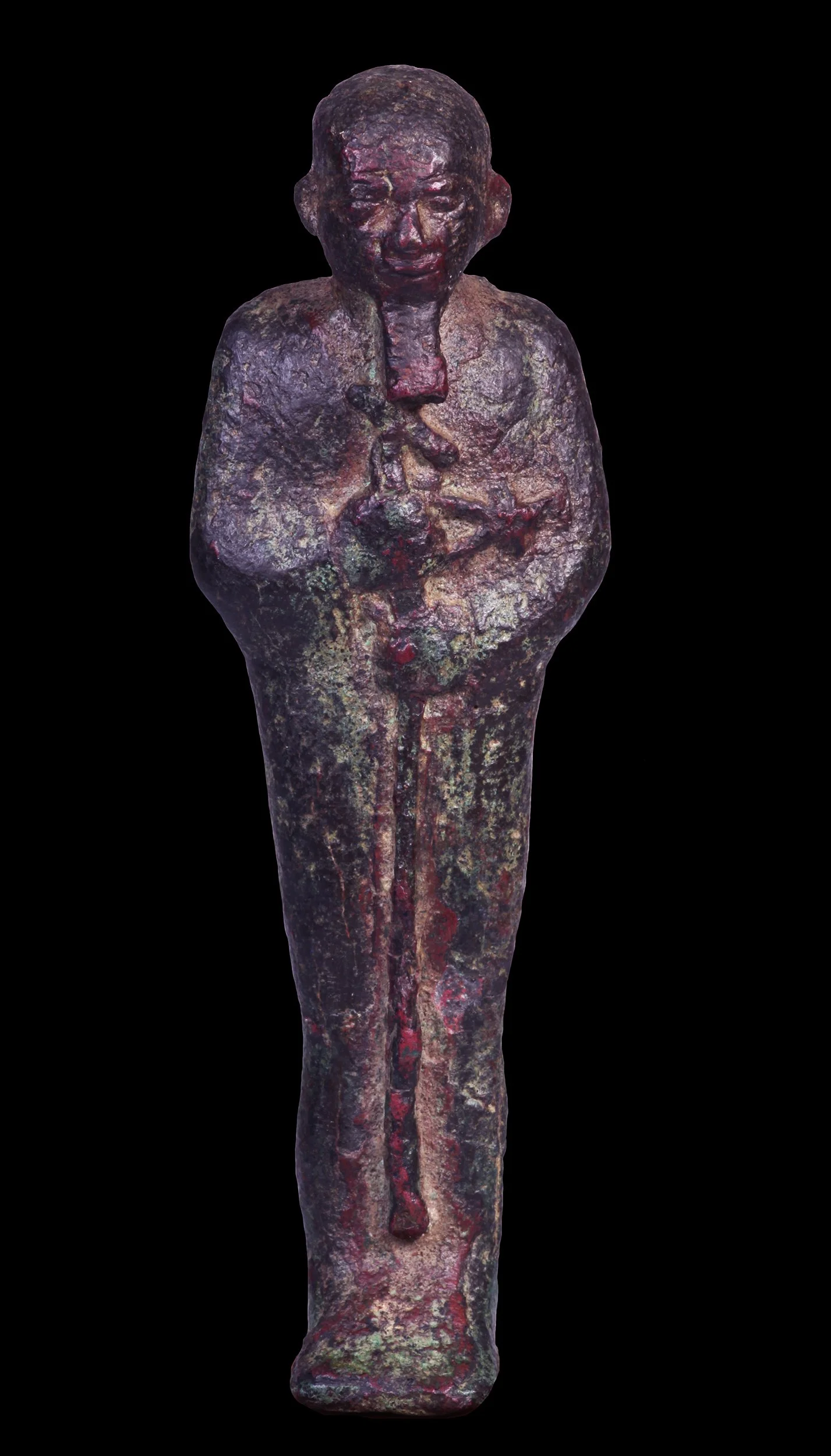 Ancient bronze statue of a standing man with a somber expression and crossed arms, dark patina and corrosion.