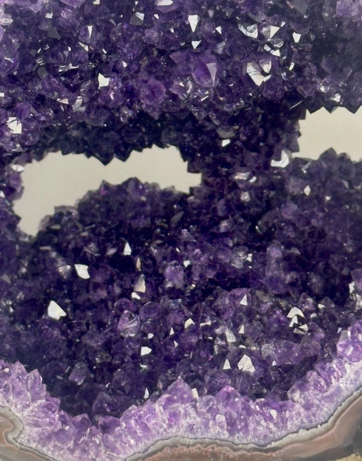 Close-up of purple amethyst geode with sparkling crystals and layered mineral formations.