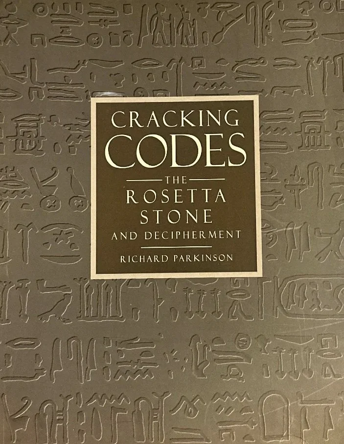 The cover of a book titled "Cracking Codes: The Rosetta Stone and Decipherment" by Richard Parkinson. The background features faint Egyptian hieroglyphs.
