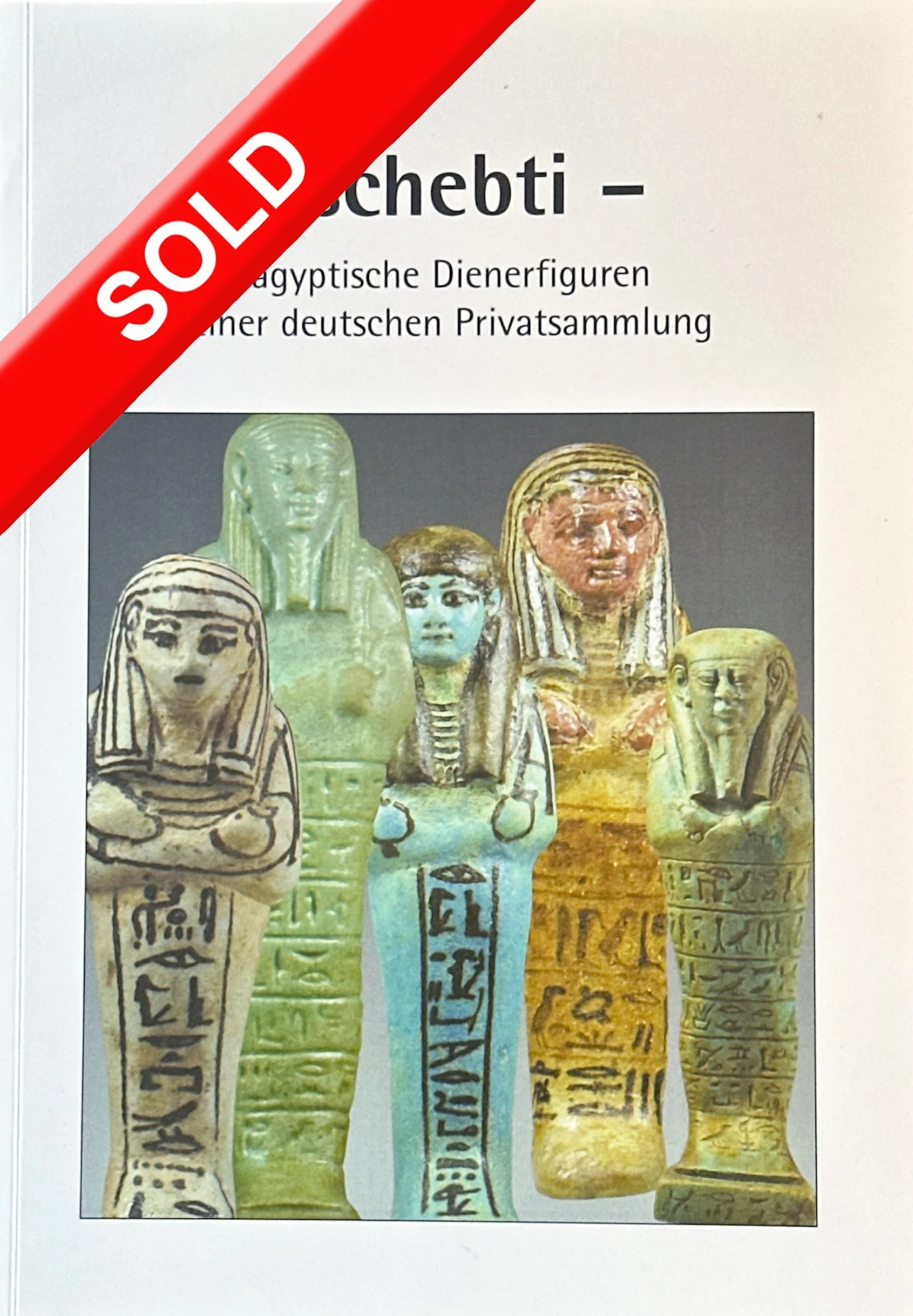 Photo of ancient Egyptian coptic figurines with hieroglyphics, with a red 'SOLD' label across the top left corner.