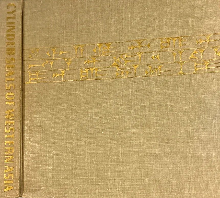 Close-up of an old beige book cover with gold lettering and embroidery, with the side text reading 'CONTRIBUTIONS OF WESTERN ASIA'.