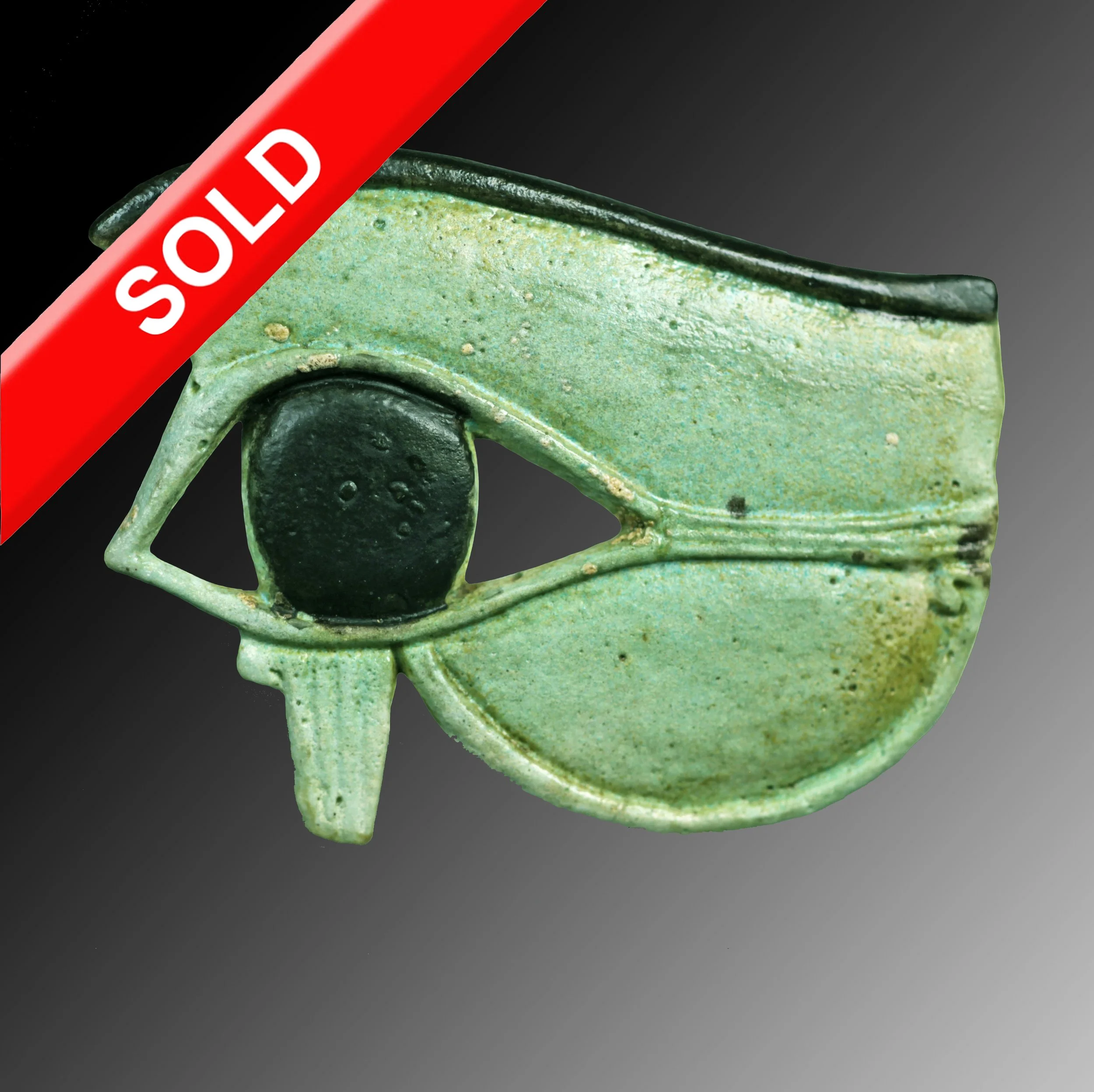 Green faience  eye with a black circle for the iris, with a green and black color scheme.