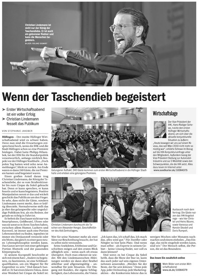 Schwarz-weiß Bild eines Mannes, der begeistert spricht und mit gestrecktem Arms in die Ferne zeigt, während er an einer Veranstaltung spricht.